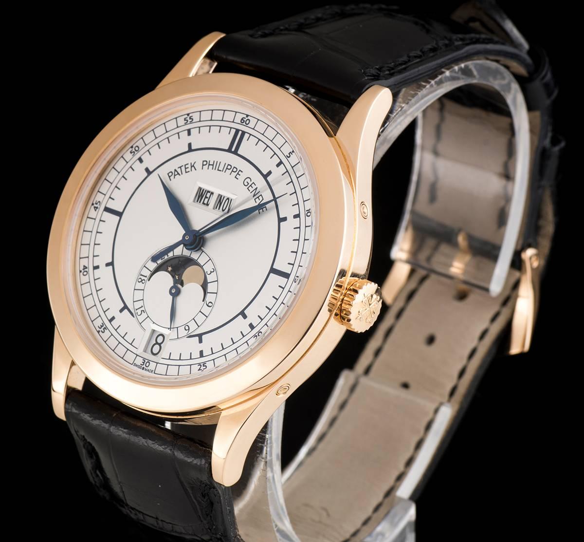 An 18k Rose Gold Annual Calendar Gents Wristwatch, silvery opaline dial with hour markers, date aperture and 24 hour indicator with moonphase at 6 0'clock, weekday and month apertures at 12 0'clock, a fixed 18k rose gold bezel, an original black