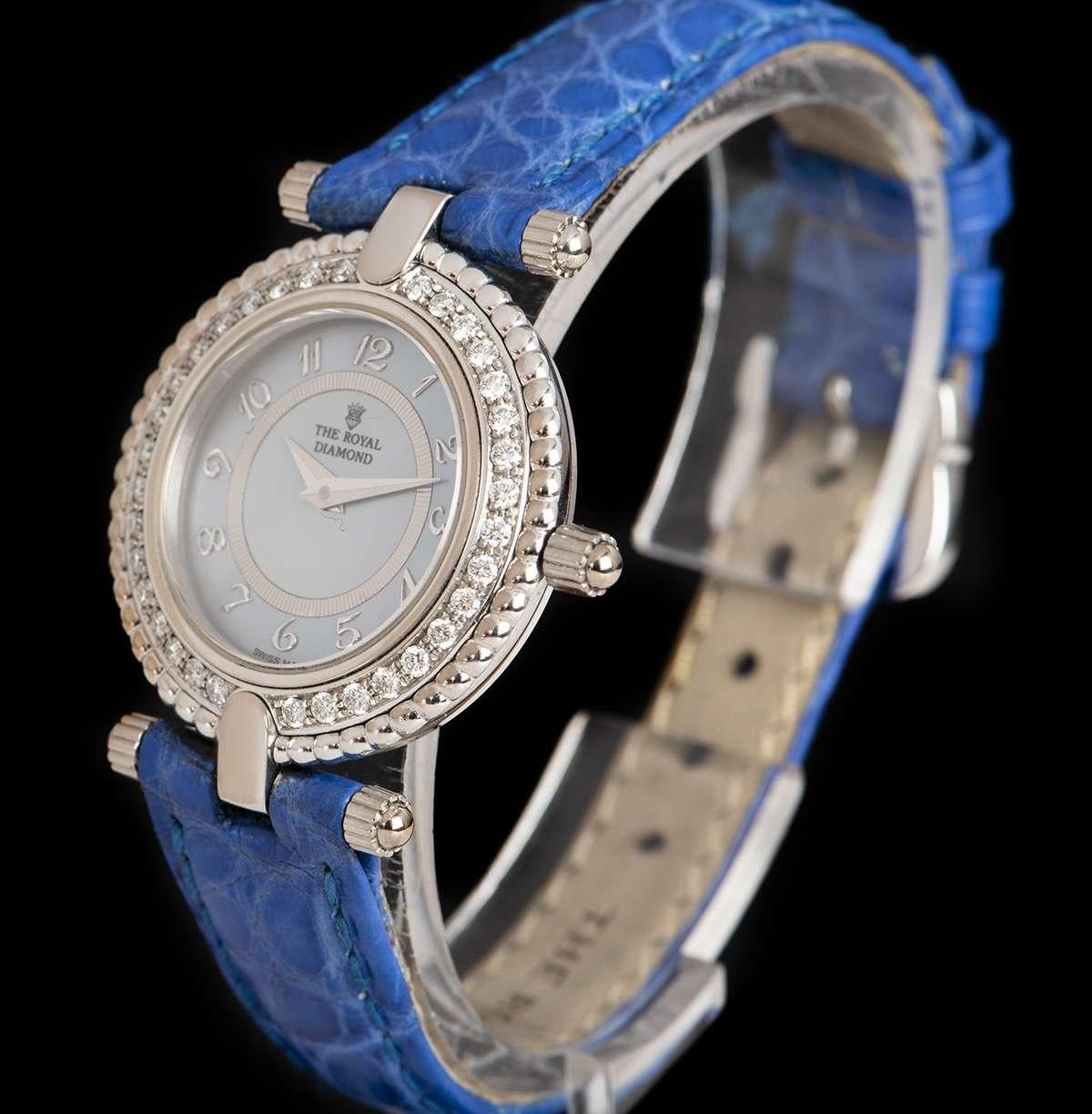 An 18k White Gold Ladies Dress Wristwatch, blue mother of pearl dial applied arabic numbers, a fixed 18k white gold bezel set with approximately 34 round brilliant cut diamonds (~0.49ct), an original blue leather strap with a stainless steel pin