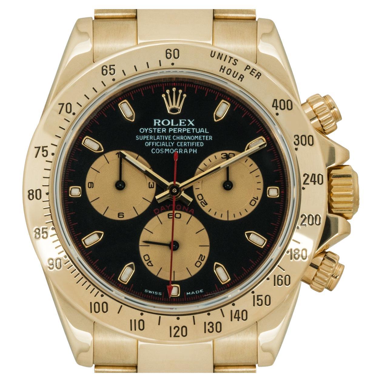 A yellow gold Cosmograph Daytona by Rolex. Featuring a black dial with contrasting outer minute track and champagne sub-dials as well as a yellow gold tachymeter bezel.

Fitted with a sapphire glass, a self-winding Cosmograph movement and an Oyster