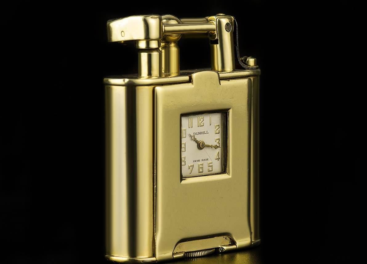 A Rare 1930s Vintage 18k Yellow Gold Combined Swing Arm Petrol Lighter and Pocket Watch, square cream dial signed Dunhill with arabic numbers, an 18k yellow gold rounded rectangular body with a hinged front containing the watch, signed Dunhill on