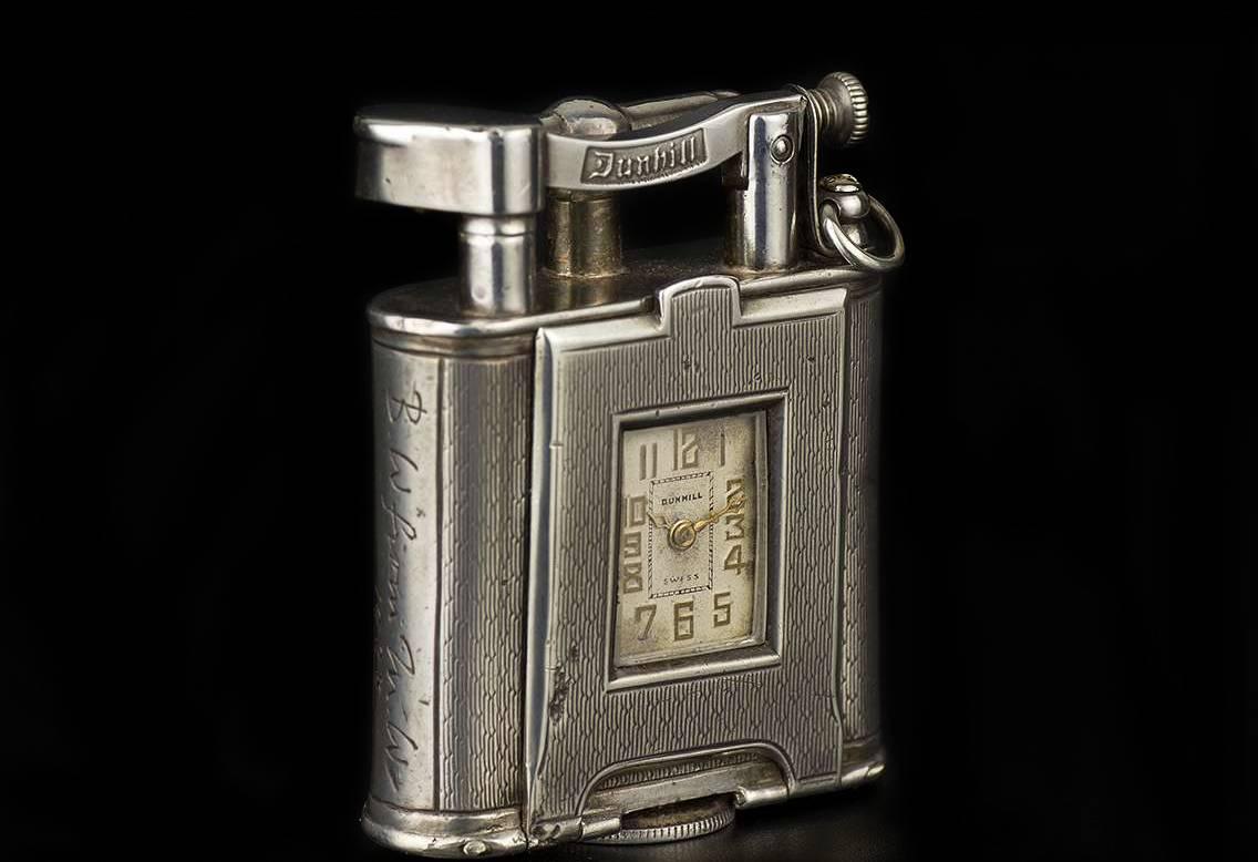 A Rare Circa 1930s Vintage Sterling Silver Combined Swing Arm Petrol Lighter and Pocket watch, rectangular silver dial signed Dunhill with applied arabic numbers, a rounded sterling silver rectangular body with a hinged front containing the watch,