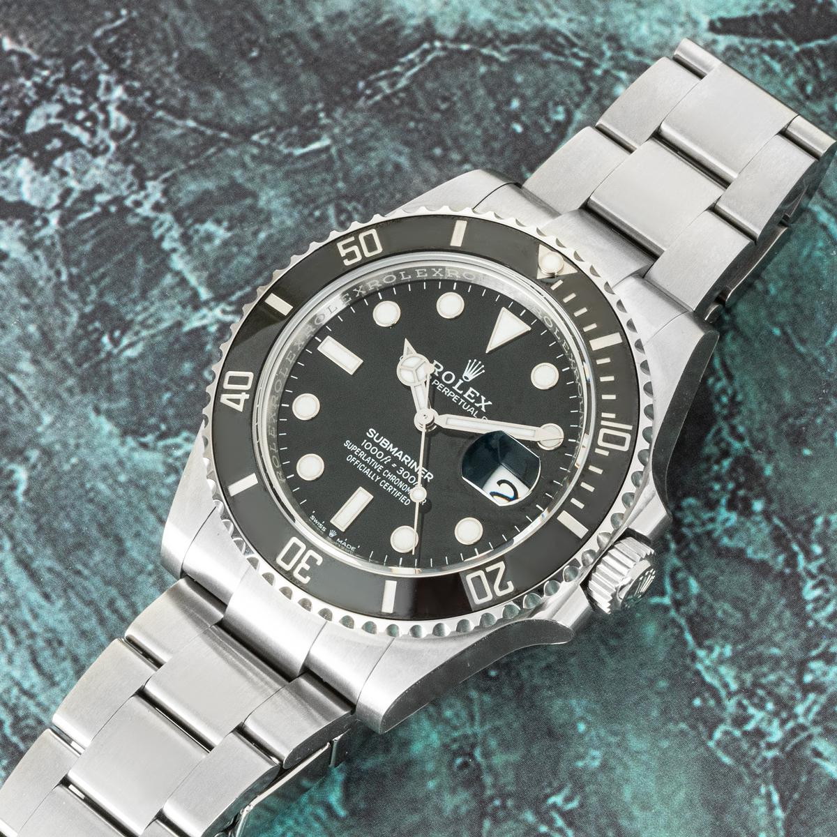 Eine ungetragene 41mm Submariner Date in Oystersteel von Rolex. Das schwarze Zifferblatt wird durch eine einseitig drehbare Lünette aus schwarzer Keramik mit 60-Minuten-Teilung ergänzt, die mit Platin beschichtet ist.

Ausgestattet mit kratzfestem