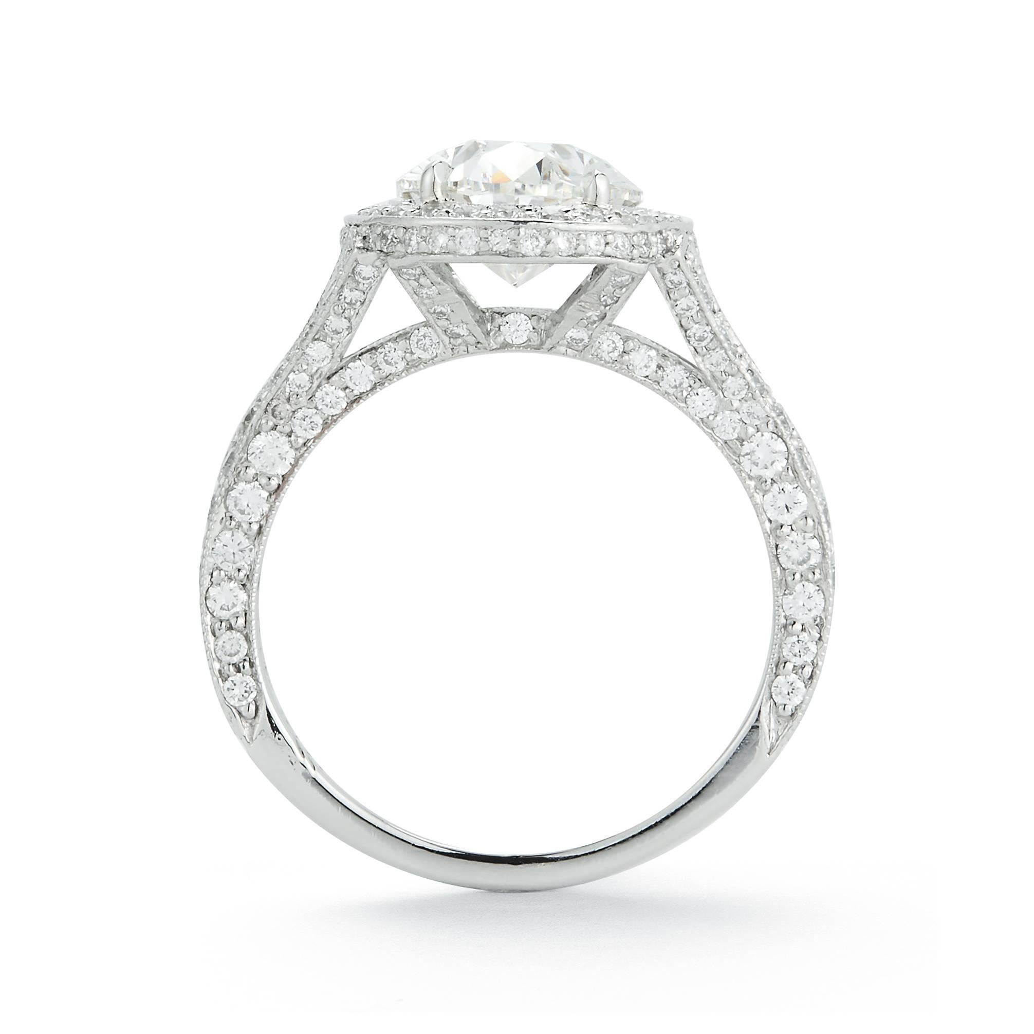 Set with an oval-cut diamond, weighing approximately 2.60 carats, within a round brilliant diamond halo and gallery to the diamond-set bifurcated shoulders, mounted in platinum

Size 5 1/4 (can be sized)

With report 17629693 dated 3 October 2017