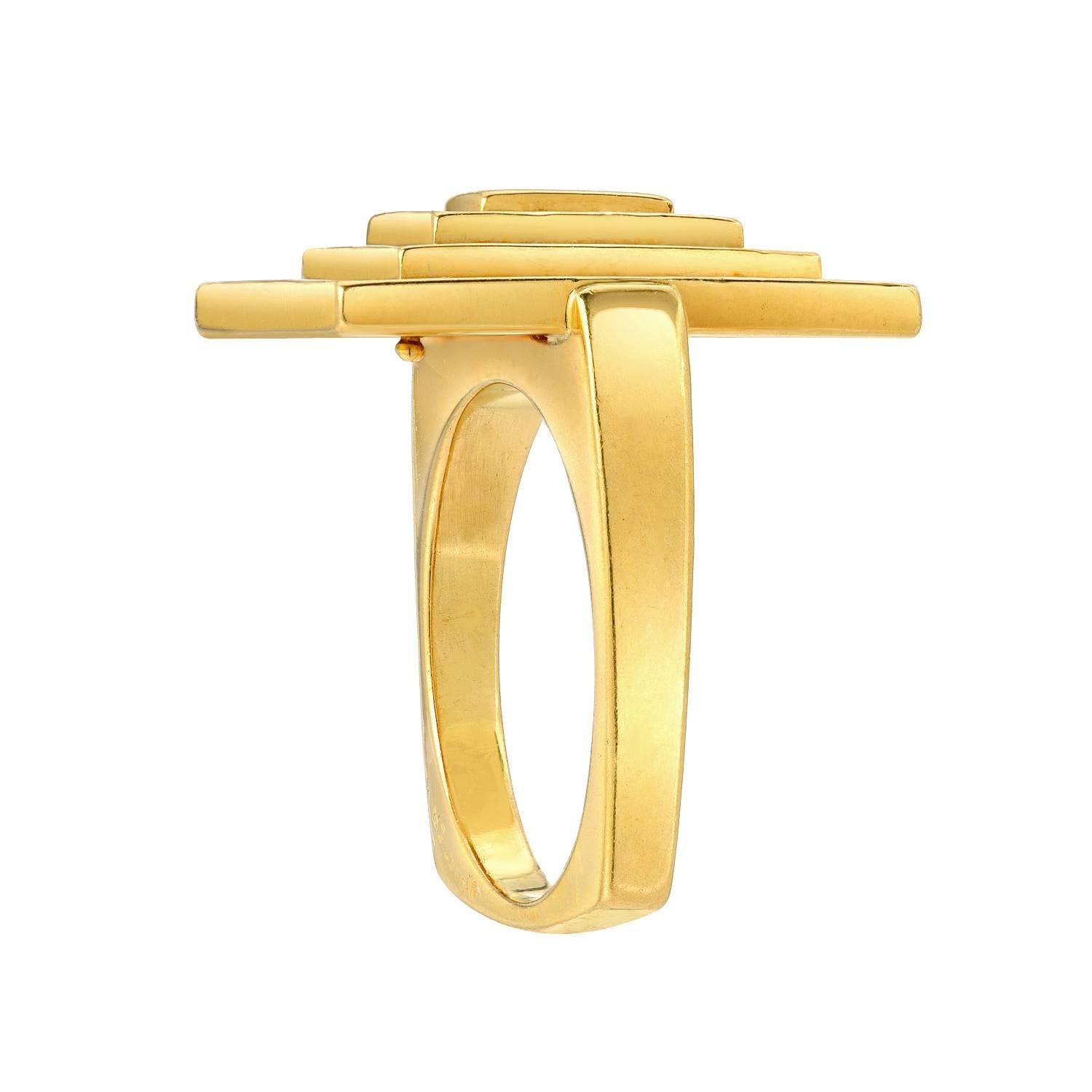 The top designed as a stepped rectangular plaque to the gold squared shank, size 5.75
