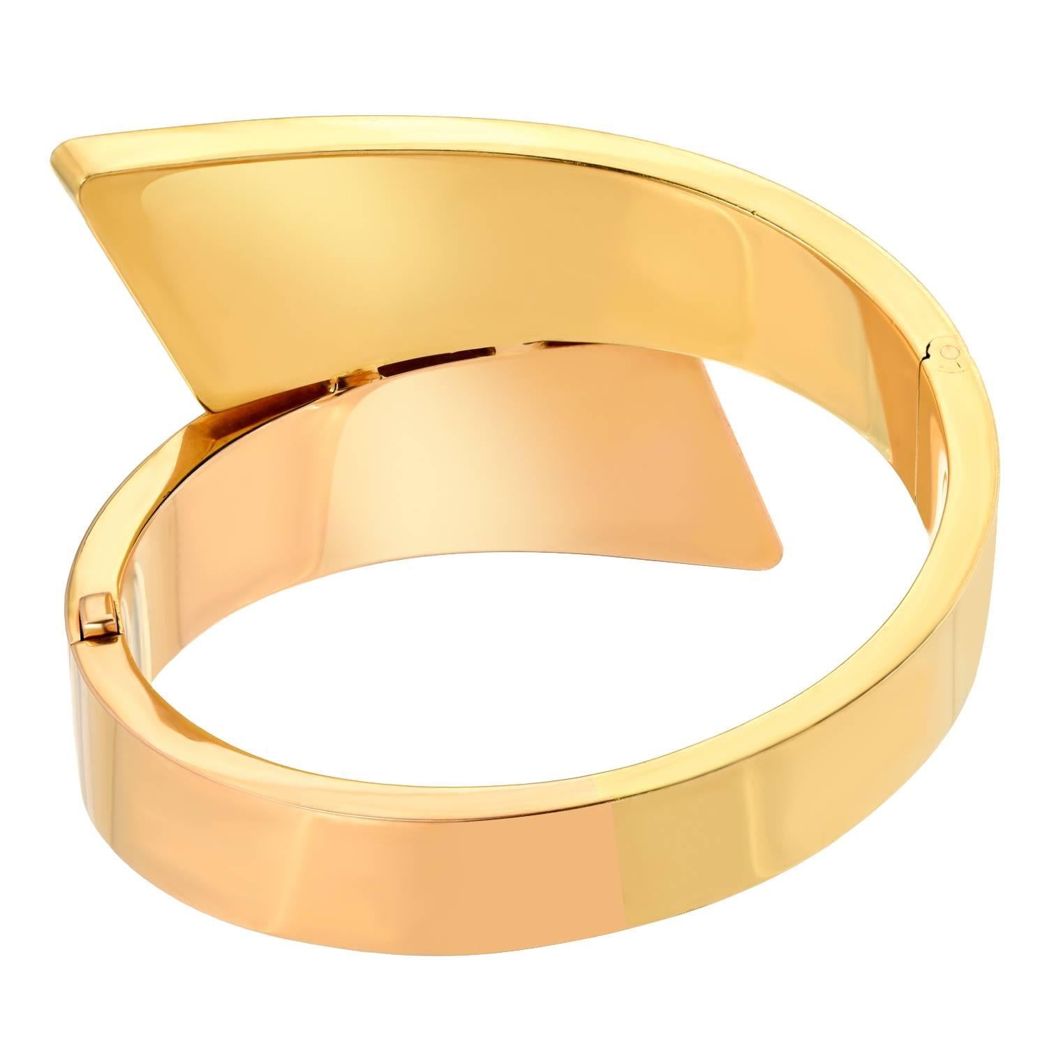 Designed with a hinged bypass motif comprising rose and yellow gold
Metal: 18k yellow and rose gold
Size/Dimensions: 17.8 cm, 4 cm at widest point
Marks: 750 S
Gross Weight: 80.5 grams
