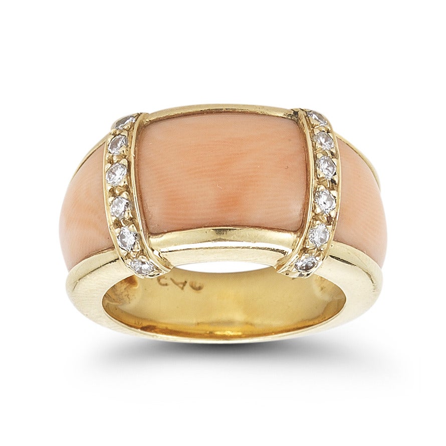 This beautiful Van Cleef & Arpels ring is set in 18KY gold, and contains coral and diamonds. The round brilliant diamonds weigh approximately .45ct in total. The 18K yellow gold mounting is signed: VCA NY, 5K877-25.

The ring is a size 5.75.