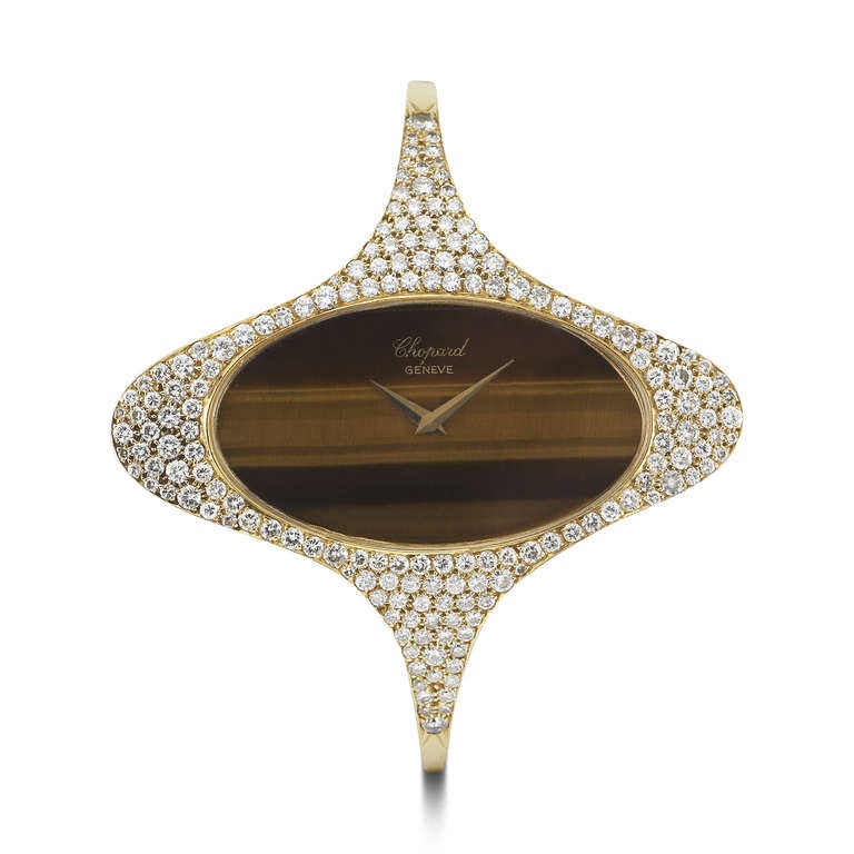 Chopard lady's 18k yellow gold and diamond-set bangle bracelet watch with tiger's eye dial. The round diamonds on the watch weigh 2.50 carats in total.