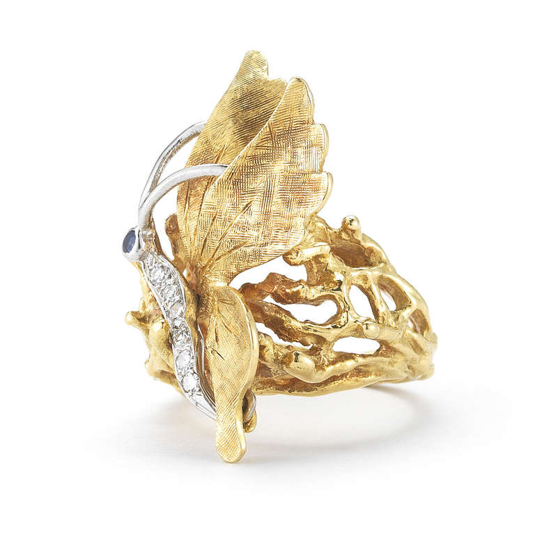 Cartier 18k gold ring of a butterfly motif set with six diamonds and one sapphire. The butterfly is done in 18k white gold which sets it apart nicely from the yellow gold twig-like setting - as if the butterfly is perched upon the twigs. Size 6.25.