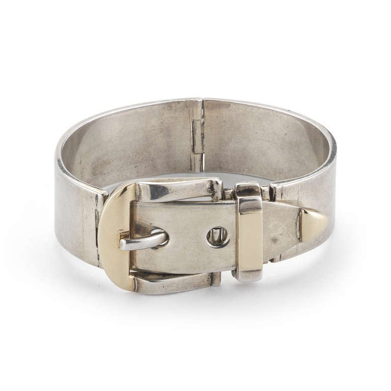 This Cartier bracelet from the 1970s is made with 14k gold and hinged with sterling silver. The bracelet has a functional buckle closure. Signed CARTIER Andre Pierre.