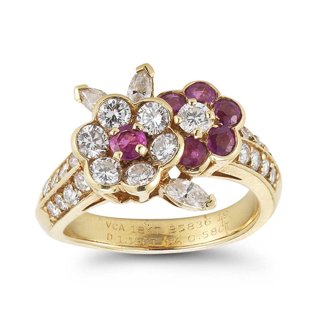 An elegant, feminine flower ring of diamonds and rubies by esteemed French jeweler Van Cleef & Arpels. This beautiful ring features 6 round rubies, weighing 0.58 carats, and round brilliant and marquise diamonds, weighing 1.13 carats. Ring is set in
