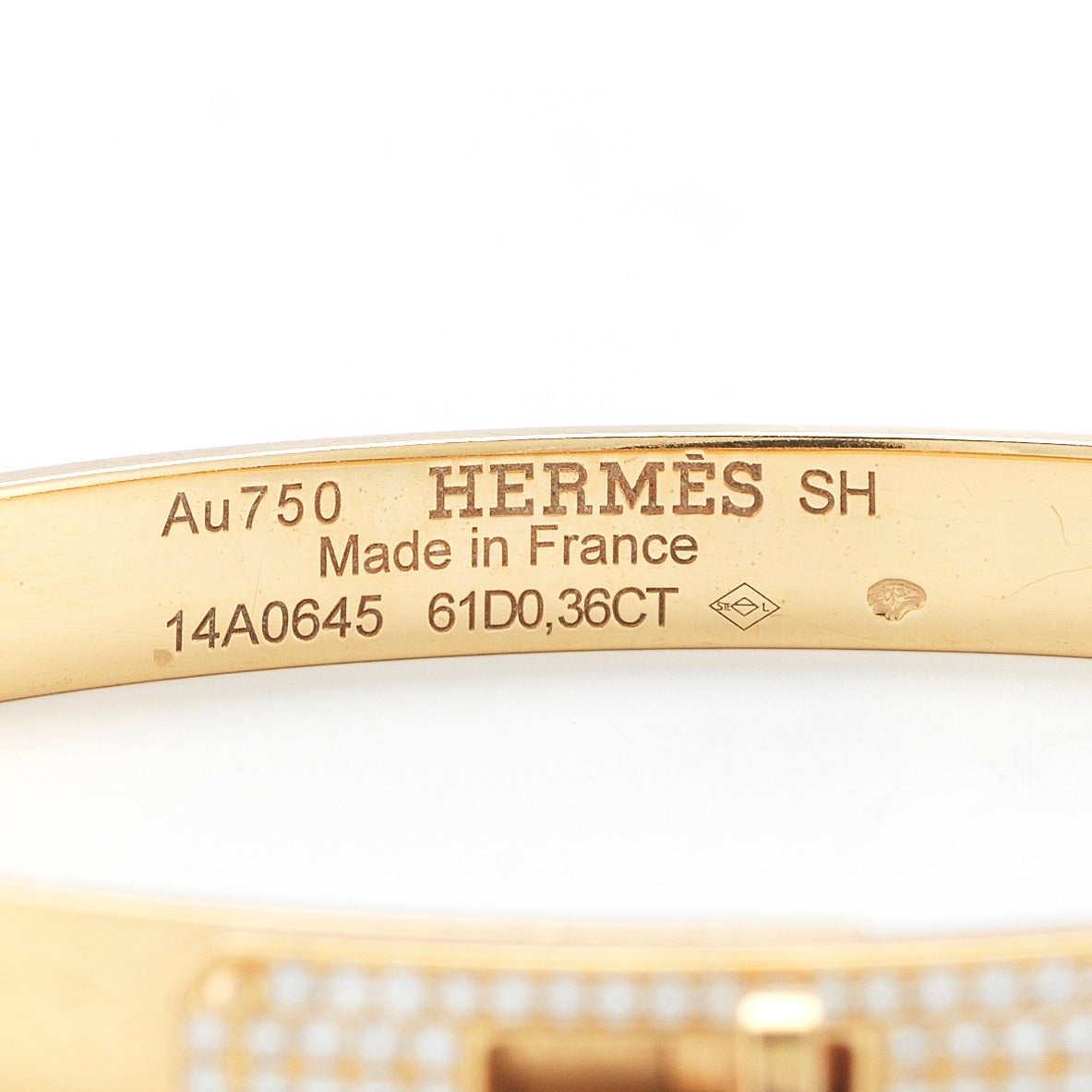 A lovely, simple, 18K yellow bangle from Hermes. The bangle has diamonds in four rows on the front, making it slightly dressier. Can be worn alone, or with other bangles.