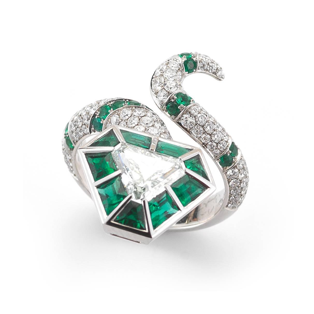 A spectacular design combining round brilliant and triangle diamonds with emeralds. The green emeralds surround the center diamond that weighs 1.16cts, is natural fancy bluish green in color, and VS1 in clarity. Ring is a size 5.5, and weighs 11.8
