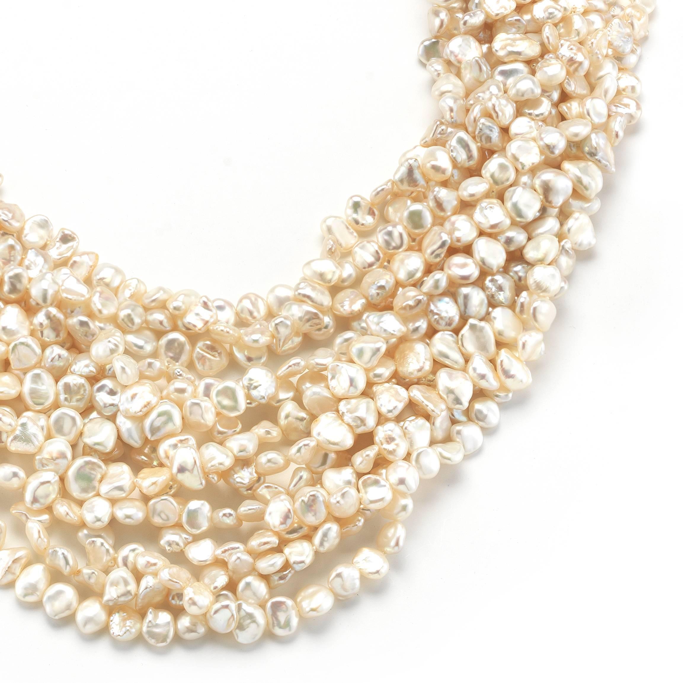 An incredibly unique and exquisite necklace from David Webb. It is composed of 13 strands of 7-9mm Biwa pearls, and a rectangular platinum/14k gold clasp with round brilliant diamonds and a faceted rock crystal.