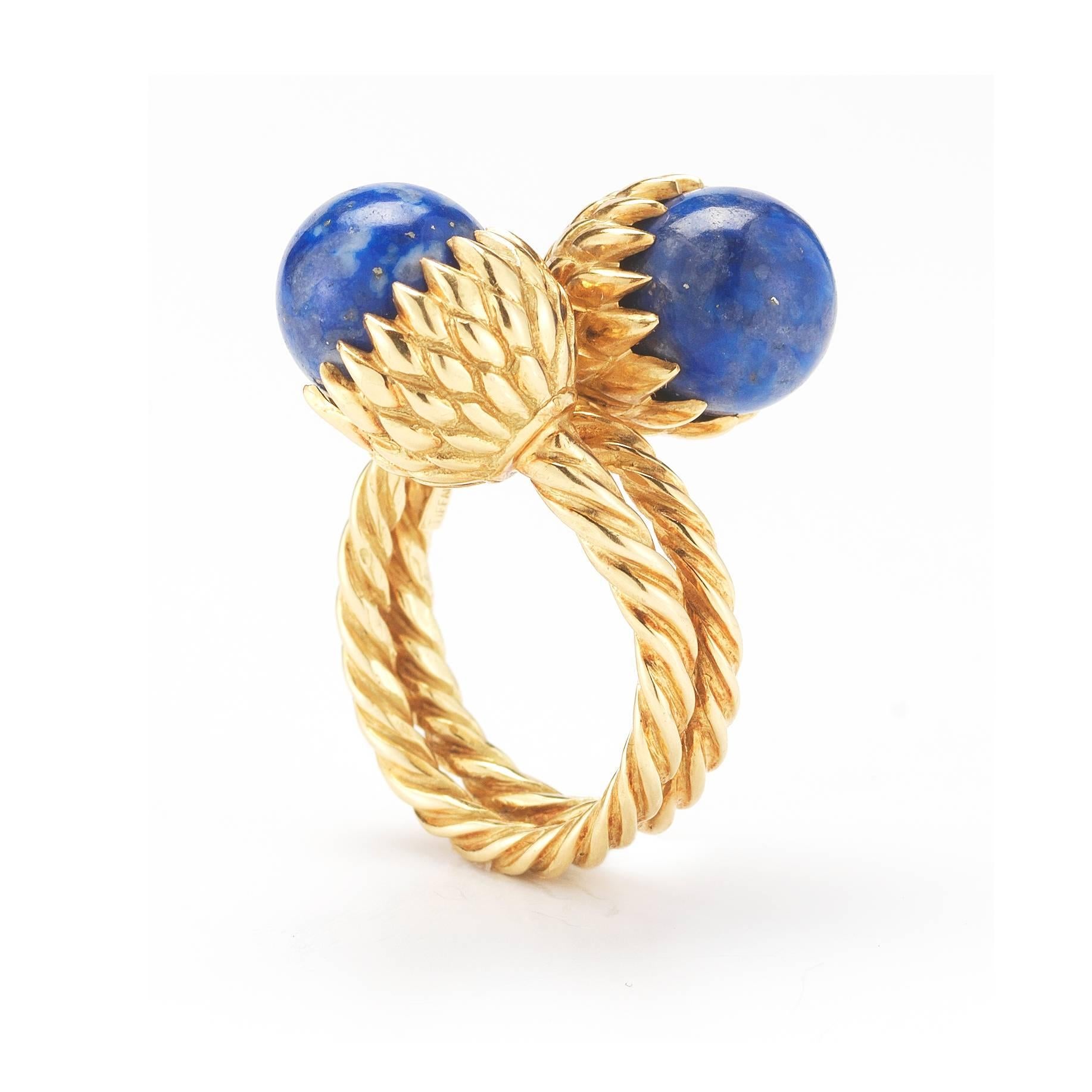 A stunning and unique ring by Tiffany & Co. Set in 18k Yellow Gold, the lapis stones bypass one another in this Schlumberger Acorn ring. Size 5.5. 