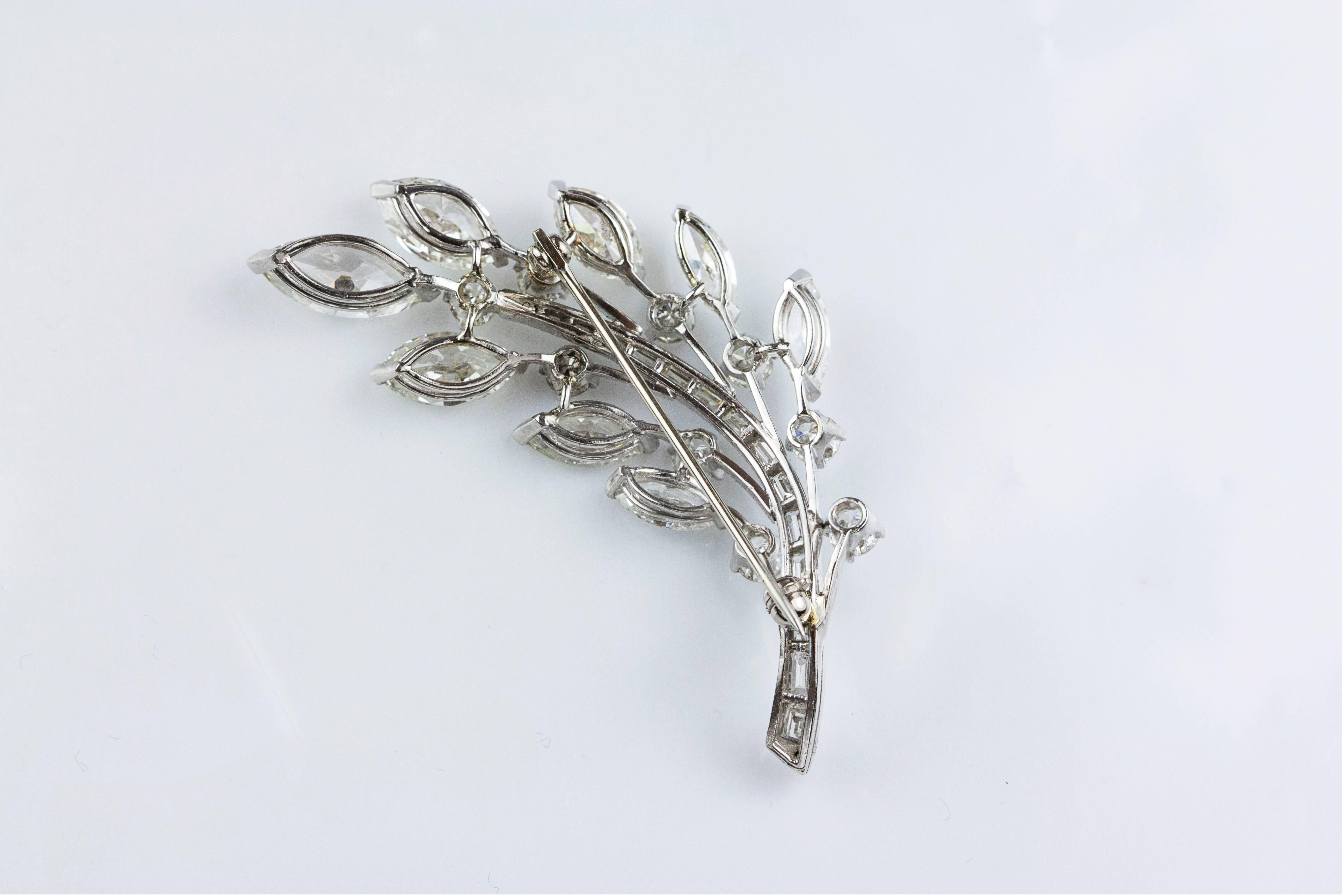 This brooch / pin has a beautiful branch with leaves design. The branch is set with 15 baguettes weighing 1.25 carats total. The leaves are set with 6.63 carats of marquee-cut diamonds accented with 1.53 carats of brilliant round diamonds. Made in
