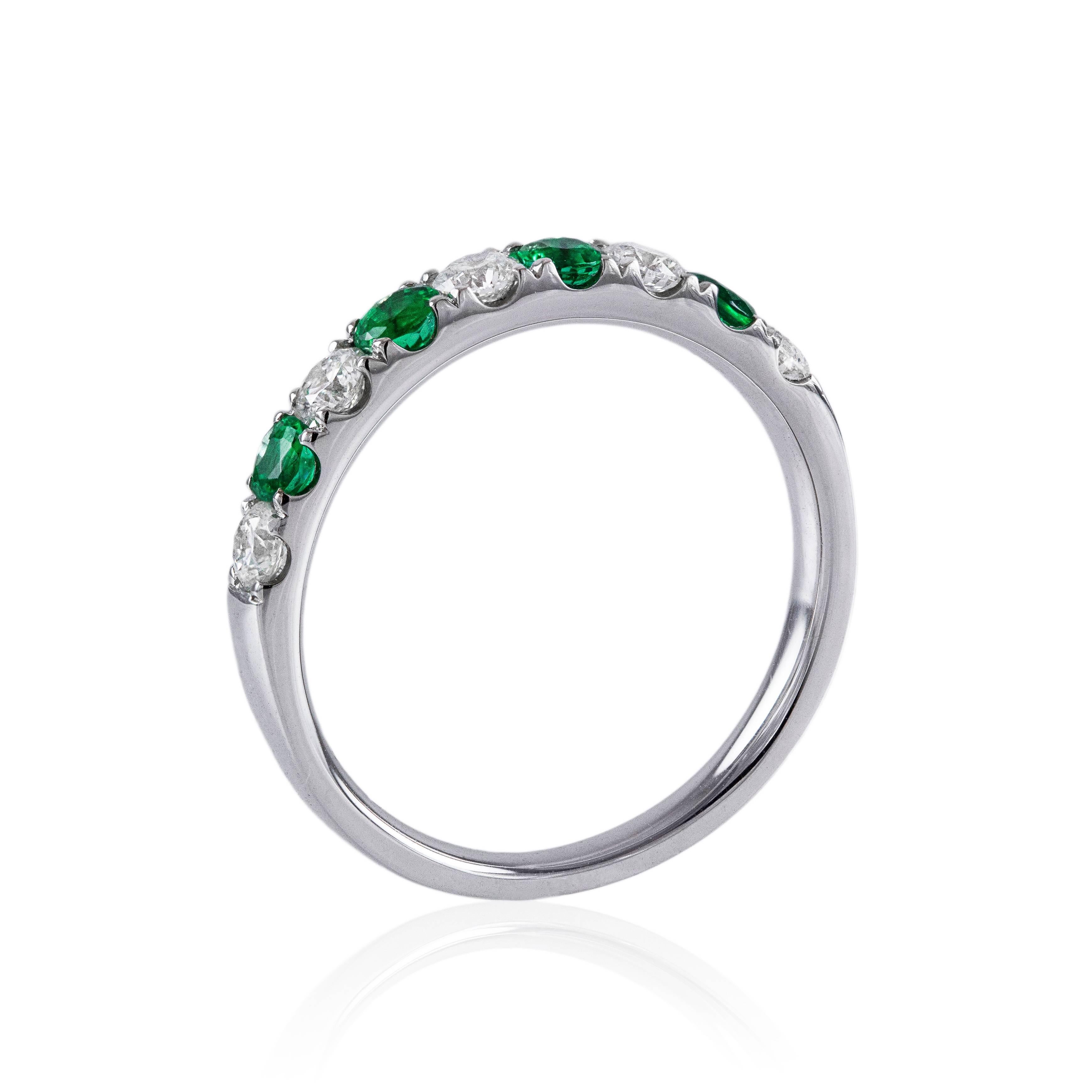 This ring features 4 round cut emeralds weighing 0.36 carats total that alternate with 5 brilliant round diamonds weighing 0.41 carats total. The diamonds are set in 18k white gold. Size 6 1/2 (sizable). A gorgeous piece.