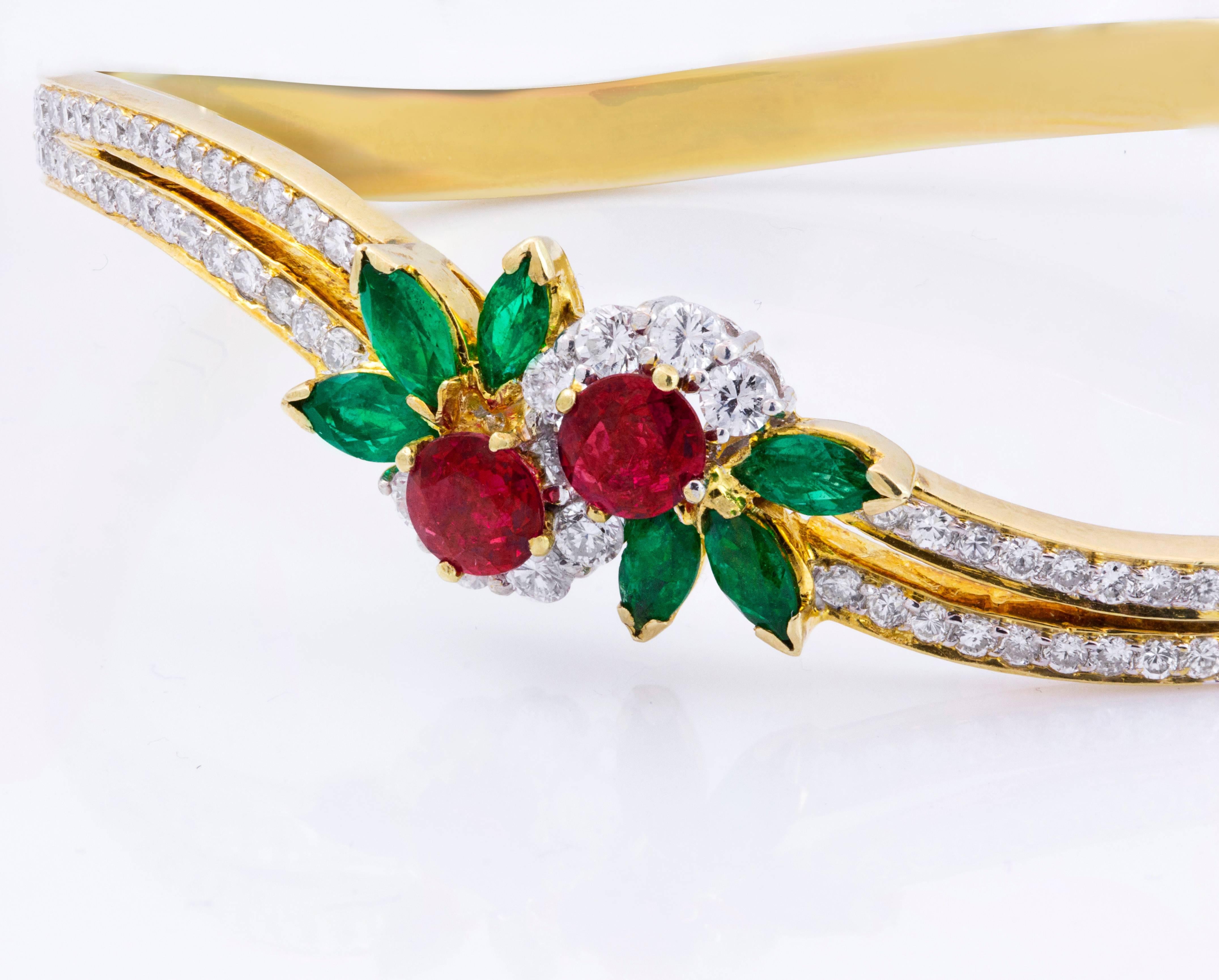 This beautiful bracelet is an estate piece that features 2 rubies weighing 1.05 carats total accented with brilliant round diamonds around. Set with marquise cut emeralds weighing 1.20 carats total on each side of the emerald. Looks like a flower