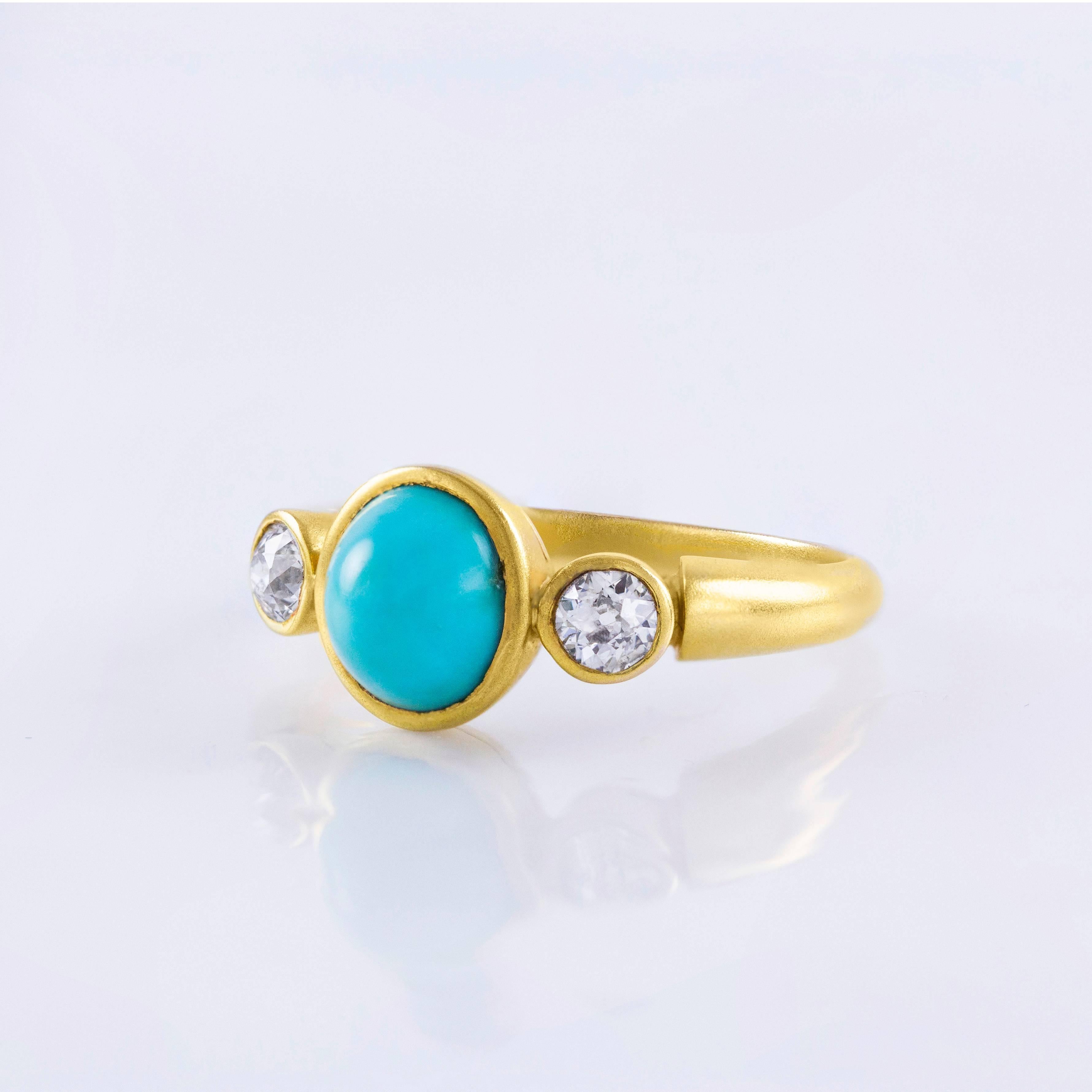 This ring is an estate piece set with a natural light blue turquoise center stone flanked by 2 old european cut diamond side stones. The diamonds weigh approximately 0.50 carats total. Made in 18k yellow gold. Size 8.5 US (sizable).