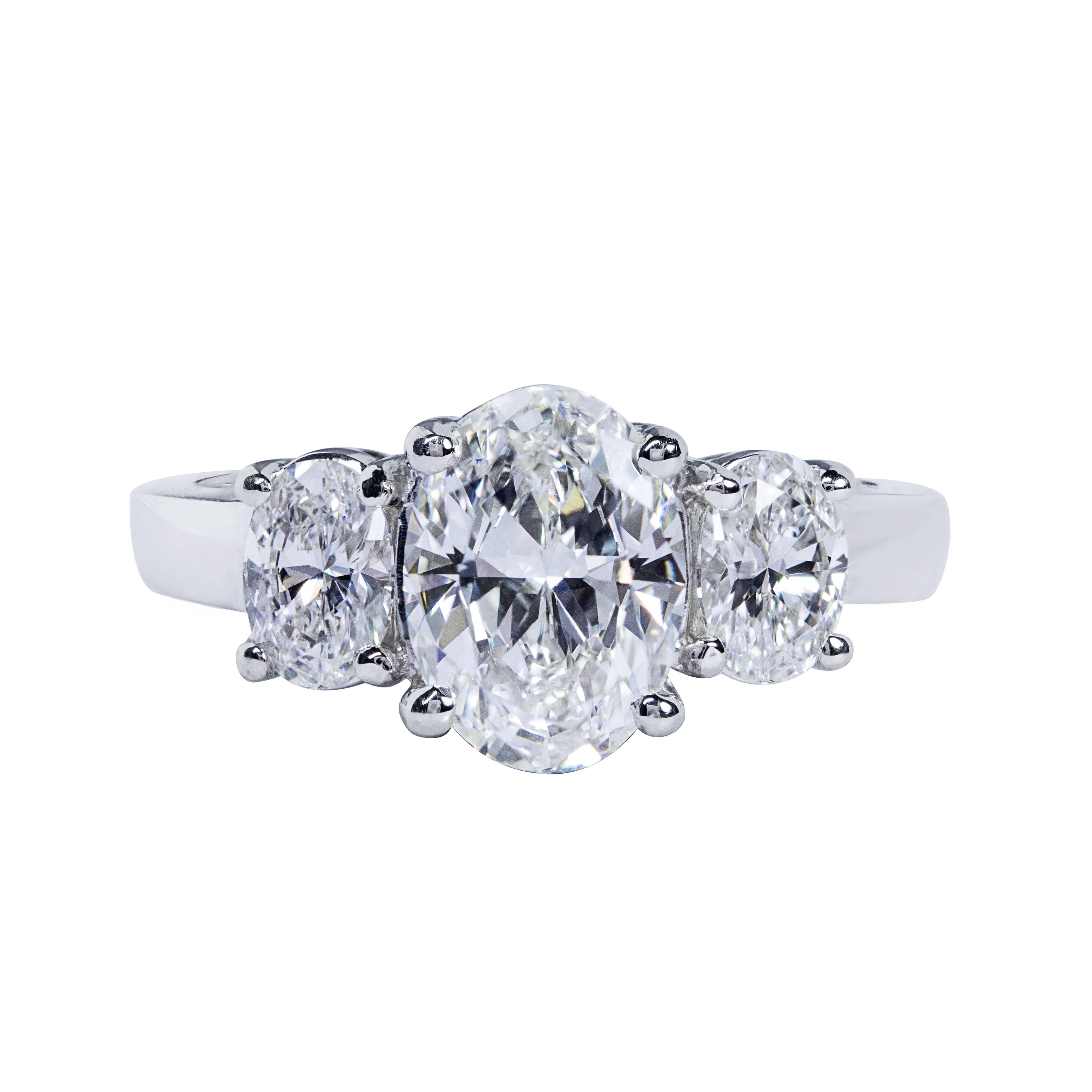 This ring features a 1.51 carat oval cut diamond center stone that GIA certified as J color and VS1 Clarity. The center diamond is flanked by 2 oval cut diamond side stones weighing 0.70 carats total. Made in platinum. Size 6 US (sizable upon