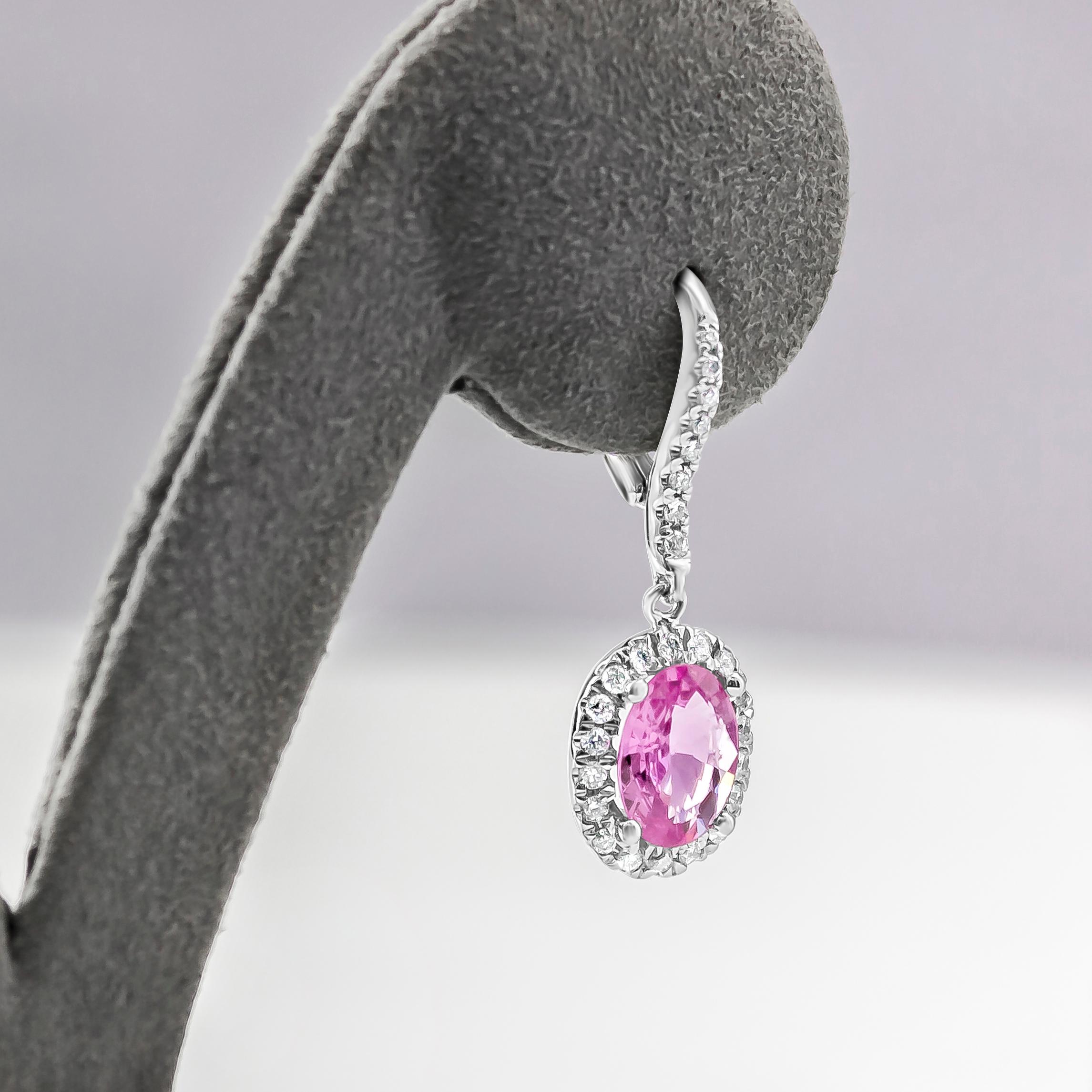 Pair of dangle earrings set with oval cut pink sapphires weighing 2.29 carats total, surrounded by brilliant round diamonds. Attached on a diamond encrusted lever back. Diamonds weigh 0.39 carats.

Style available in different price ranges. Prices