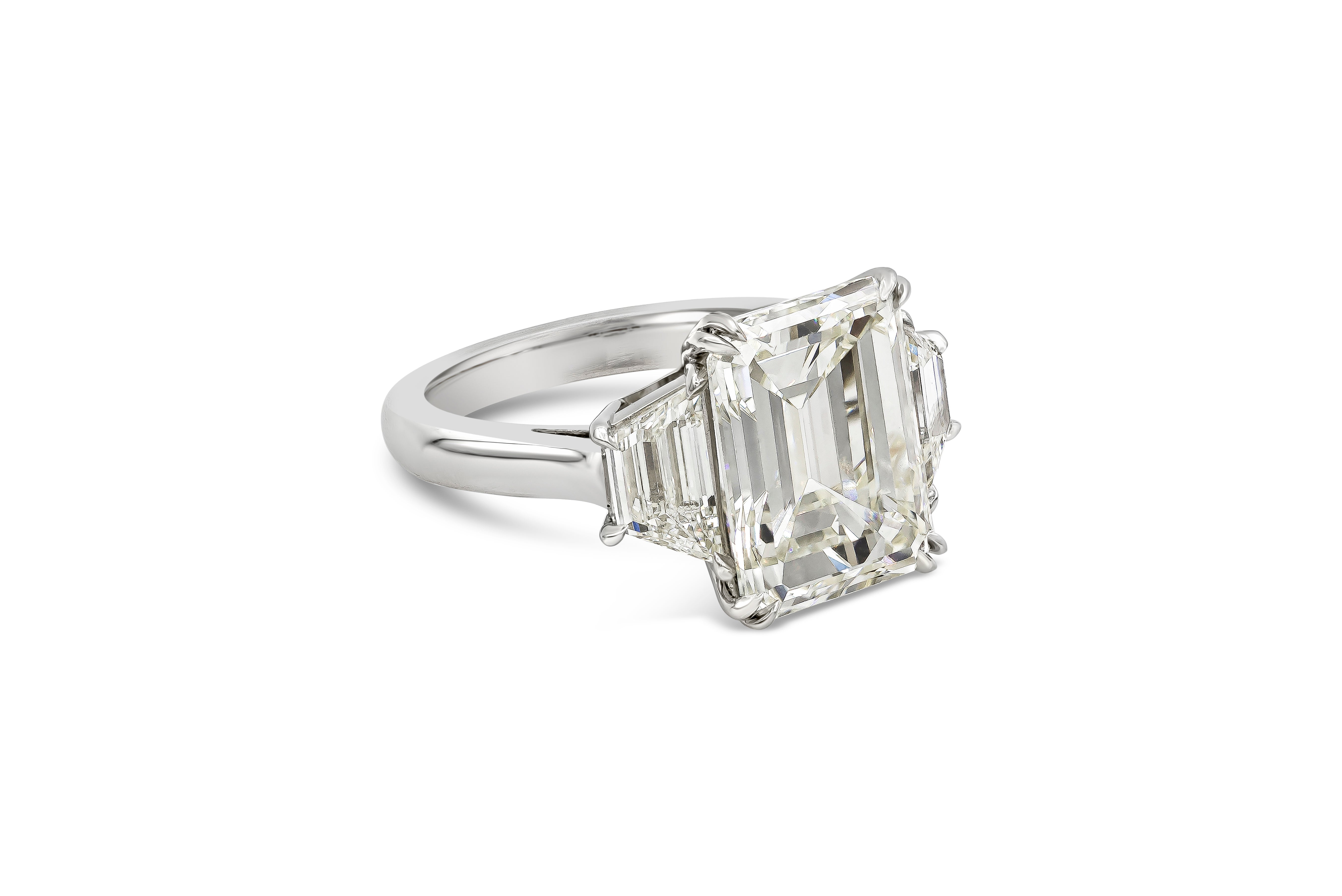 A classic and sophisticated three stone engagement ring showcasing a GIA Certified 7.31 carat emerald cut diamond, M Color and VS2 in Clarity. Flanked on each side by step-cut trapezoid diamonds weighing 1.47 carats total. Finely made with Platinum.