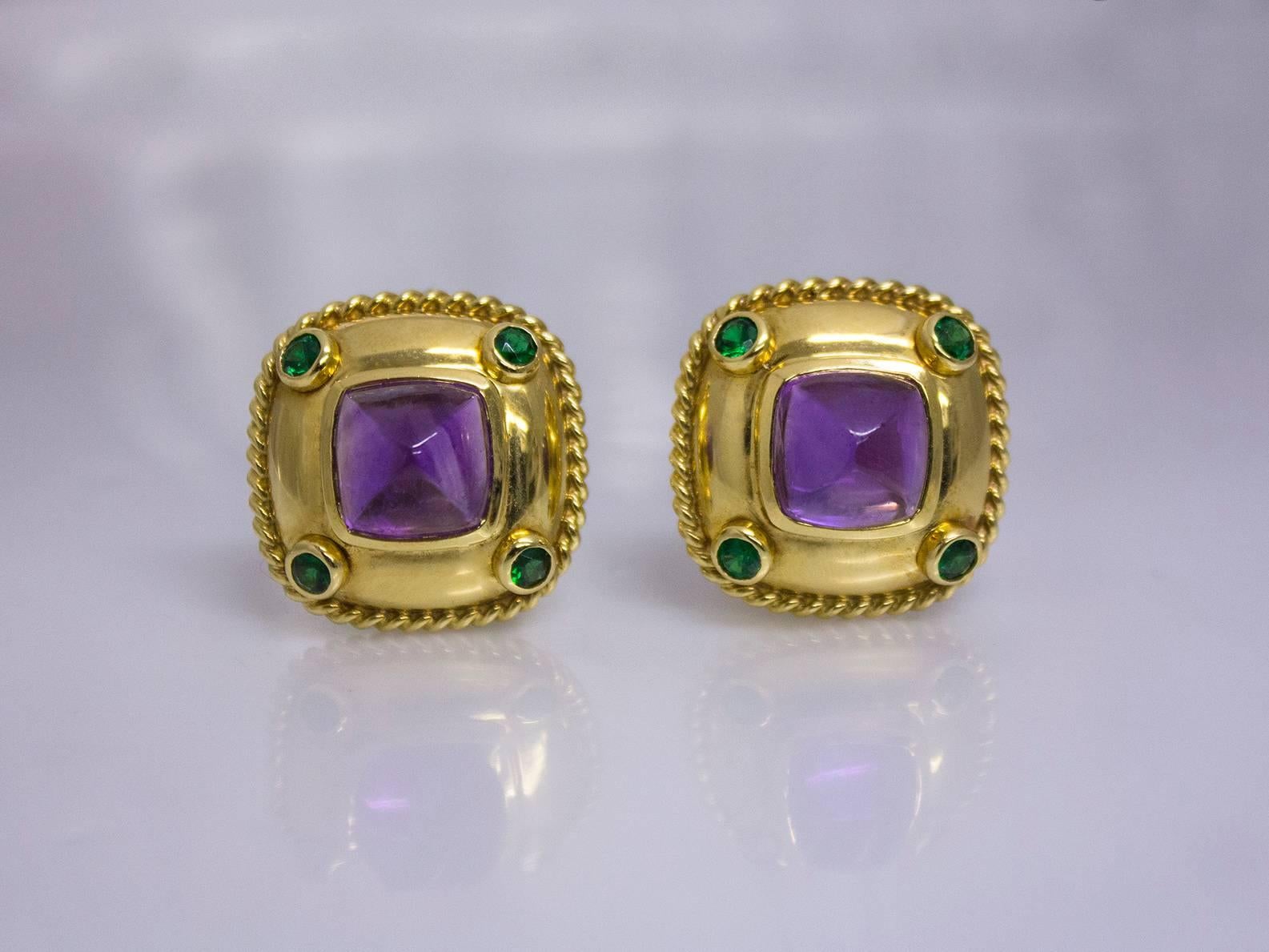 Features 2 sugarloaf cabochon amethysts, weighing 15.50 carats total bezel set in 18K yellow gold and accented by 8 round peridots, weighing 1.00 carat total. By request we can add posts to these ear clips and convert them into earrings.