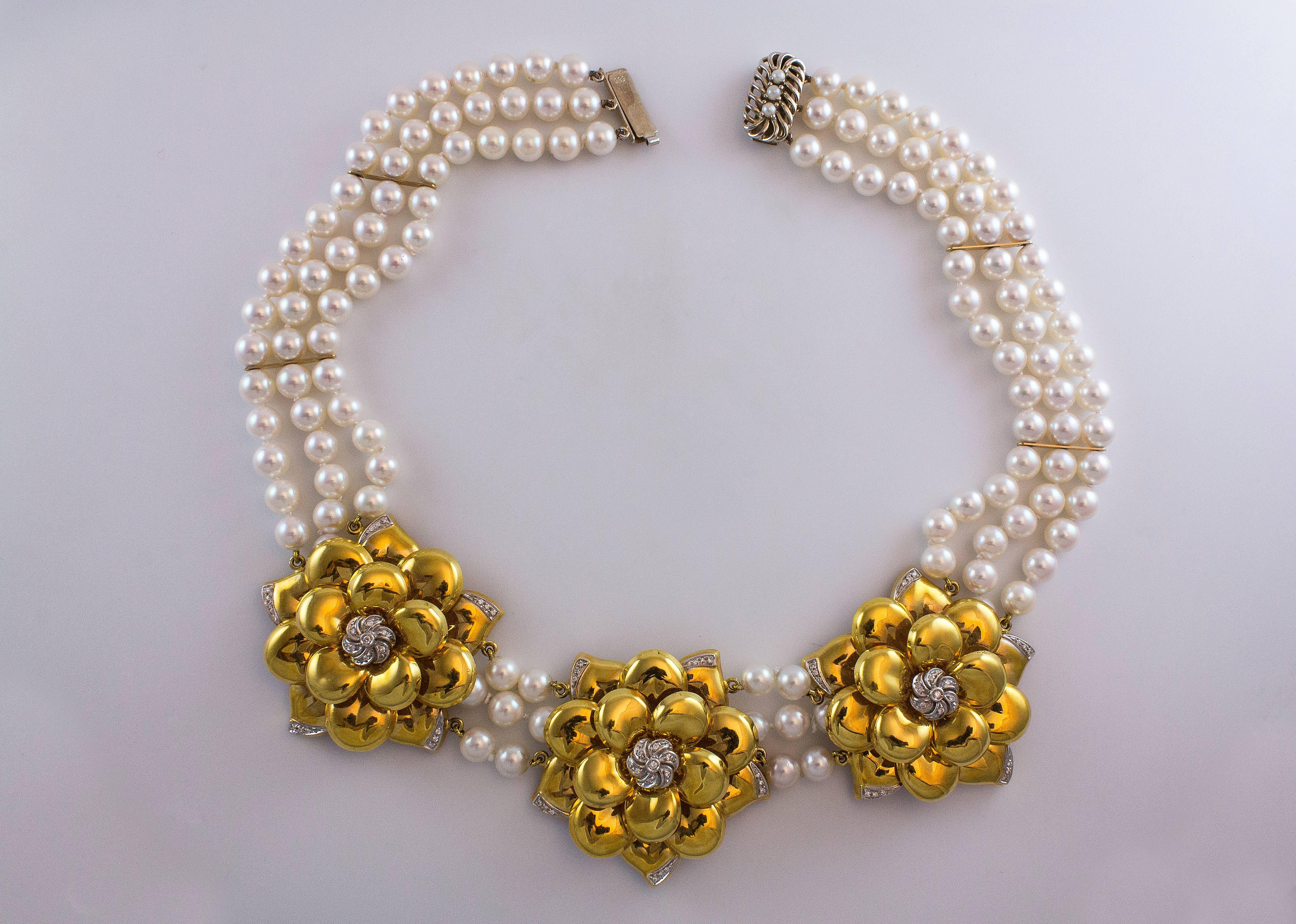 This necklace features three 18K yellow gold flowers each accented by round brilliant diamonds to the three row cultured pearl strand and 14K gold clasp. The pearls has a great luster and a beautiful pinkish tone. The gold flowers are approximately