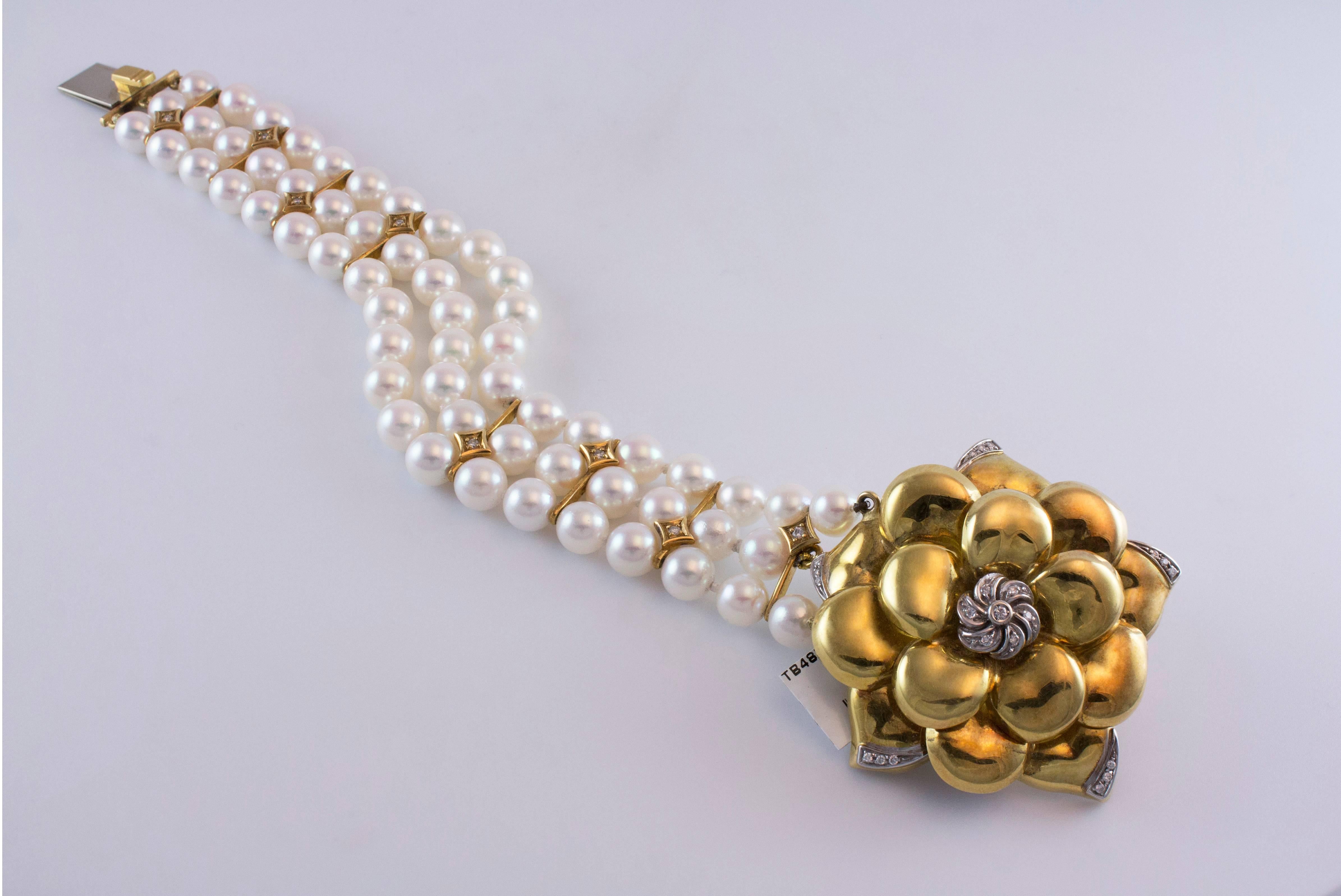 This bracelet features one 18K yellow gold flower accented by round brilliant diamonds to the three row cultured pearl strand. Total weight of diamonds approximately 0.30ct. The pearls has a great luster and a beautiful pinkish tone. The gold flower