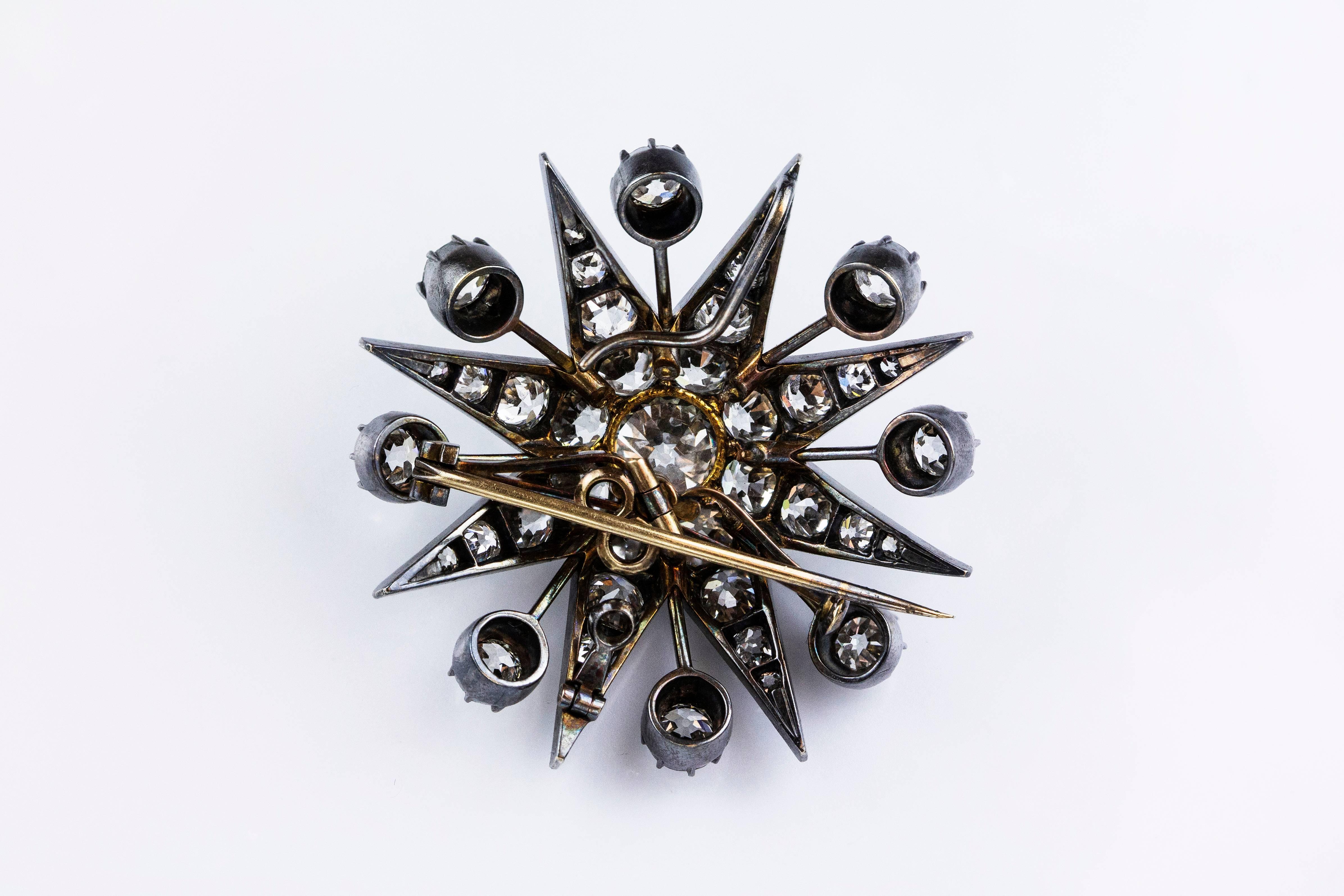 This diamond star brooch set with 49 Old European cut diamonds in a claw setting. The approximate diamond weight is 12.50 carat. Silver topped gold mounting. The brooch features a hook so it could be worn as a pendant. Also it has a special wire on