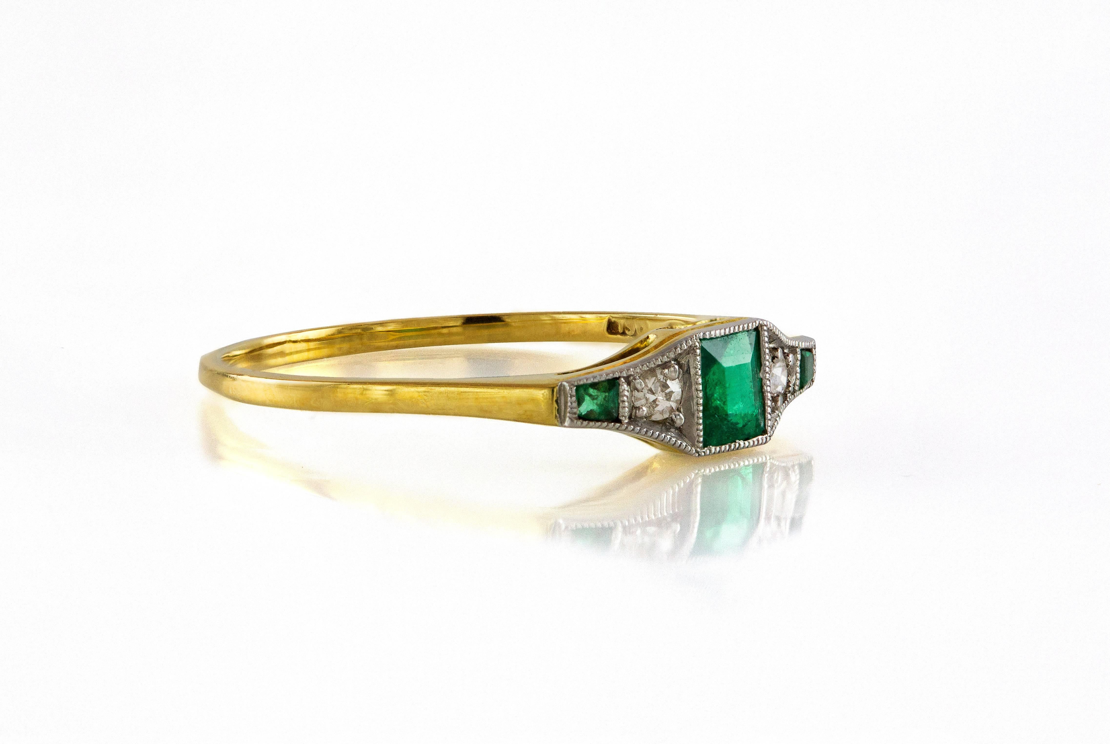 This antique ring features one square emerald in the center and 2 smaller tapered emeralds on each side separated by single cut diamonds. Total weight of emeralds is approximately 0.17 carat and total weight of diamonds is approximately 0.03 carat.