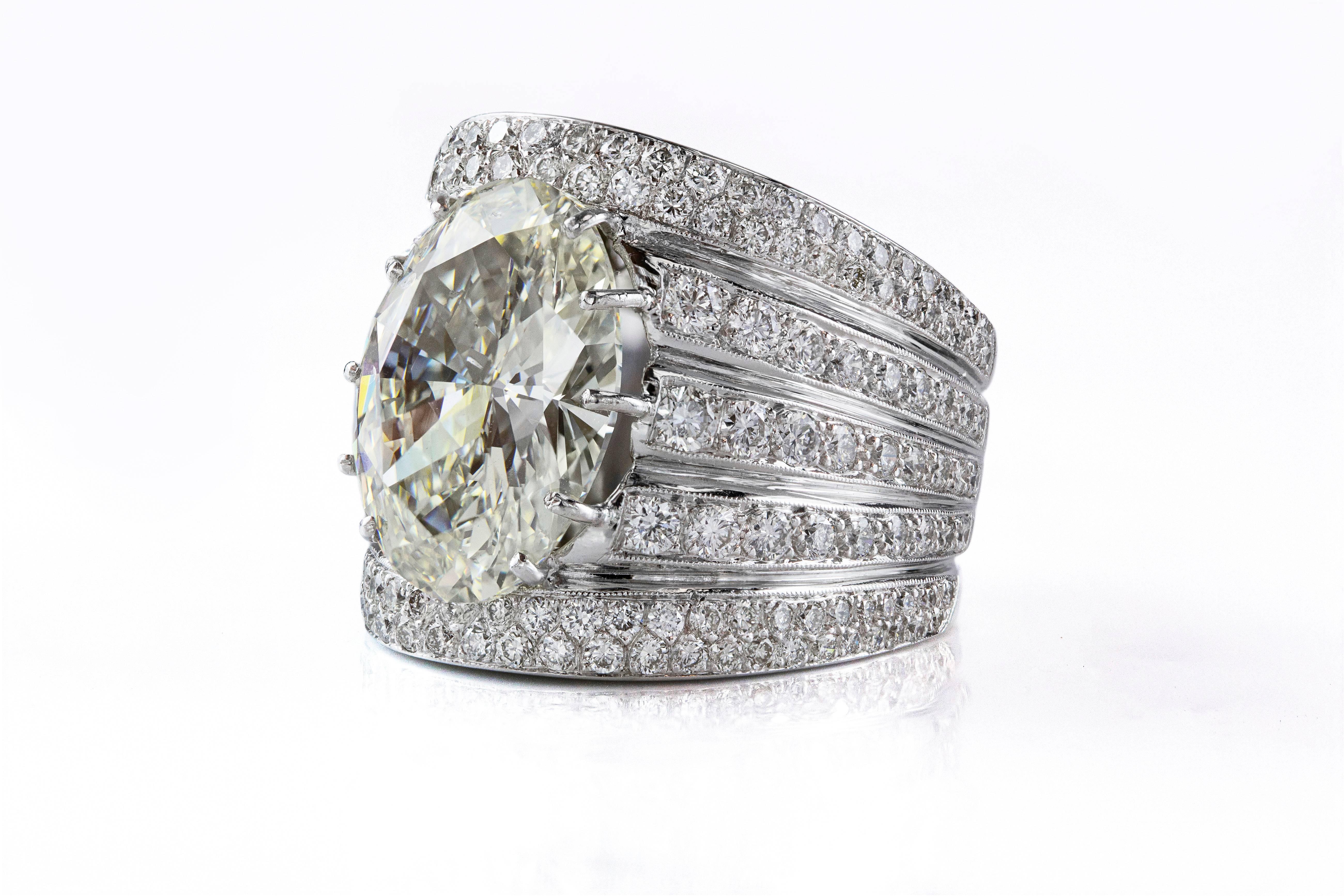 In der Mitte des Rings befindet sich ein Diamant im Ovalschliff mit einem Gewicht von 10,78 Karat. Der Mittelstein ist mit 5 Reihen von runden Brillanten von insgesamt 3,25 Karat besetzt. Hergestellt aus Platin. Größe 7 1/2. M Farbe SI1