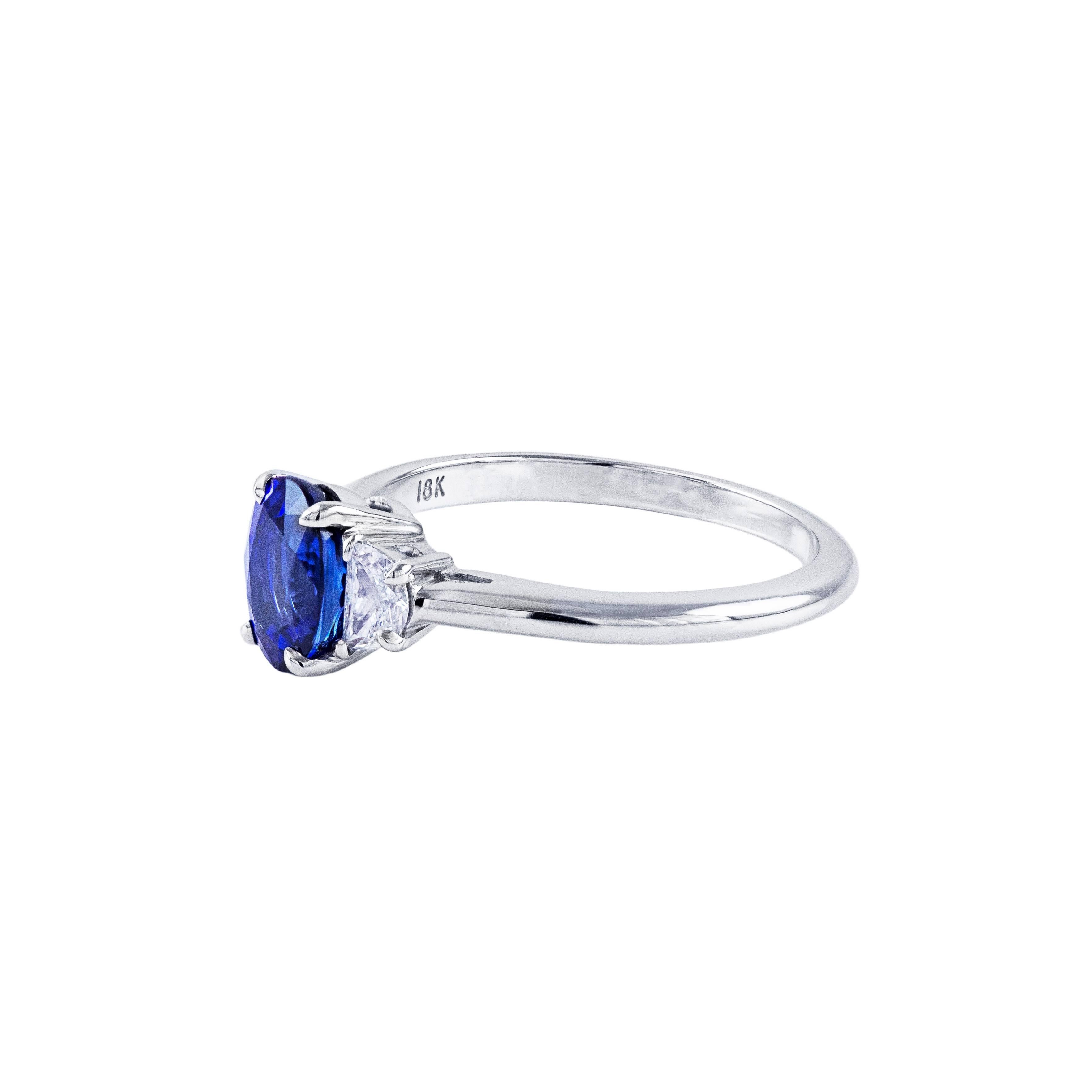 This ring features a 1.33 carat sapphire center stone. The sapphire has a beautiful deep blue color and is eye clean. The sapphire is accented by 2 half moon cut diamonds weighing 0.24 carats total. Made in 18k white gold. Size 6 (sizable). 

Style