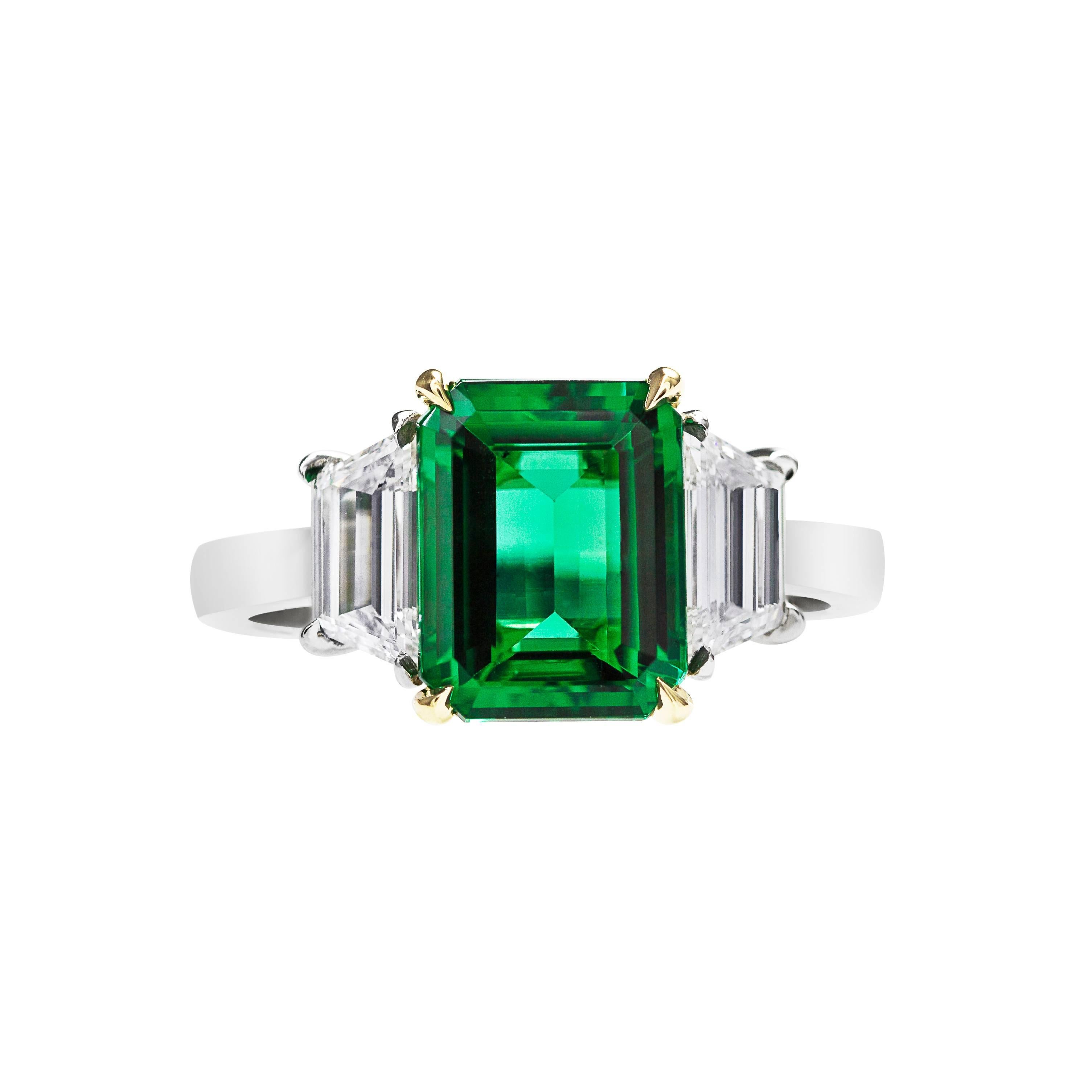 Features a gorgeous emerald cut emerald gemstone weighing 2.62 carats that AGL certified as Green color with no indication of treatment being done on the stone. An extravagant stone that is eye clean and loop clean. The emerald is flanked by