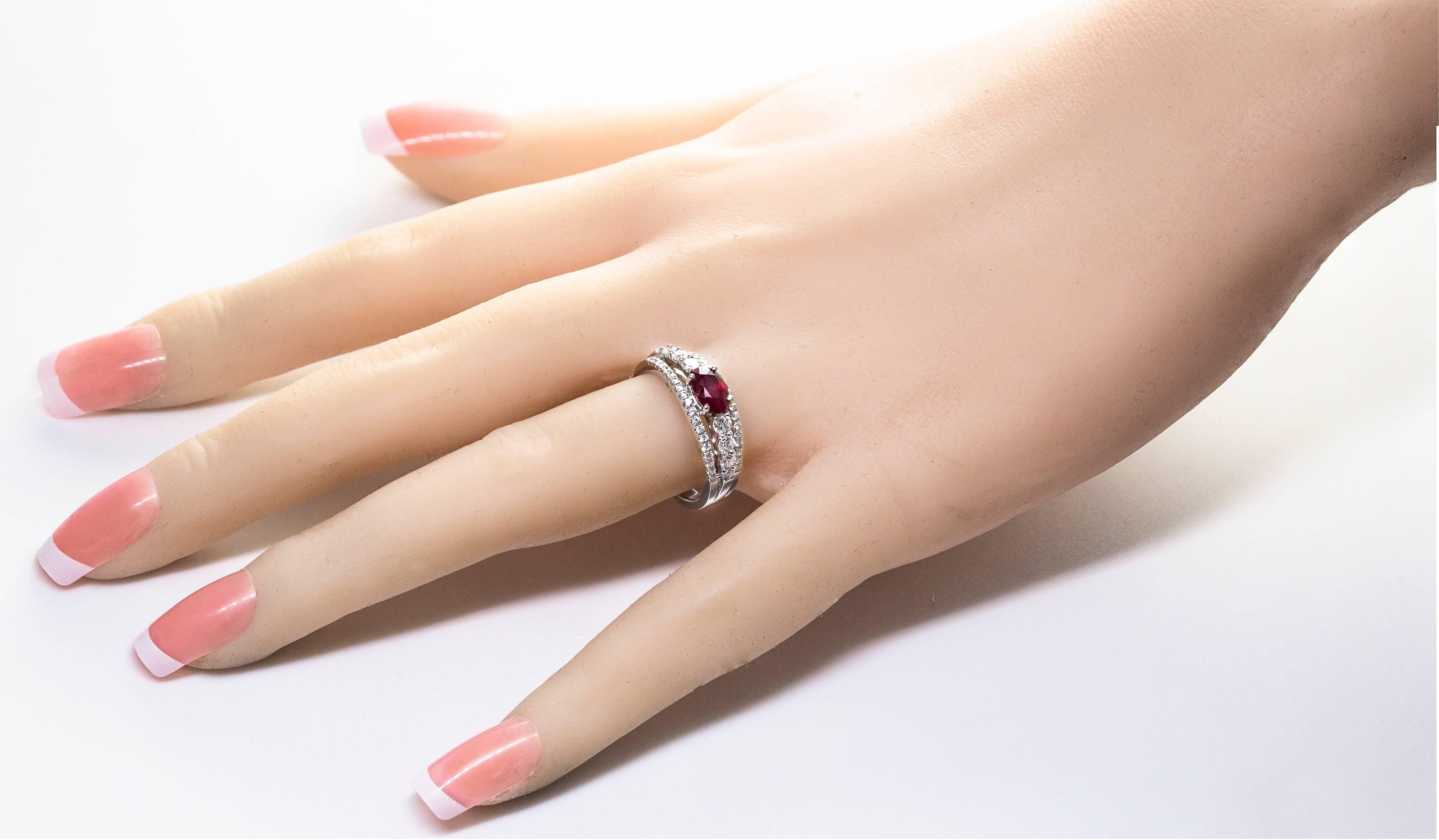 A unique ring with a 1.03 carat oval cut ruby set in a non-traditional east west fashion. 4 brilliant round full cut diamonds set on each side of the ruby. Split shank setting wherein the top and bottom part of the ring is set with round melee