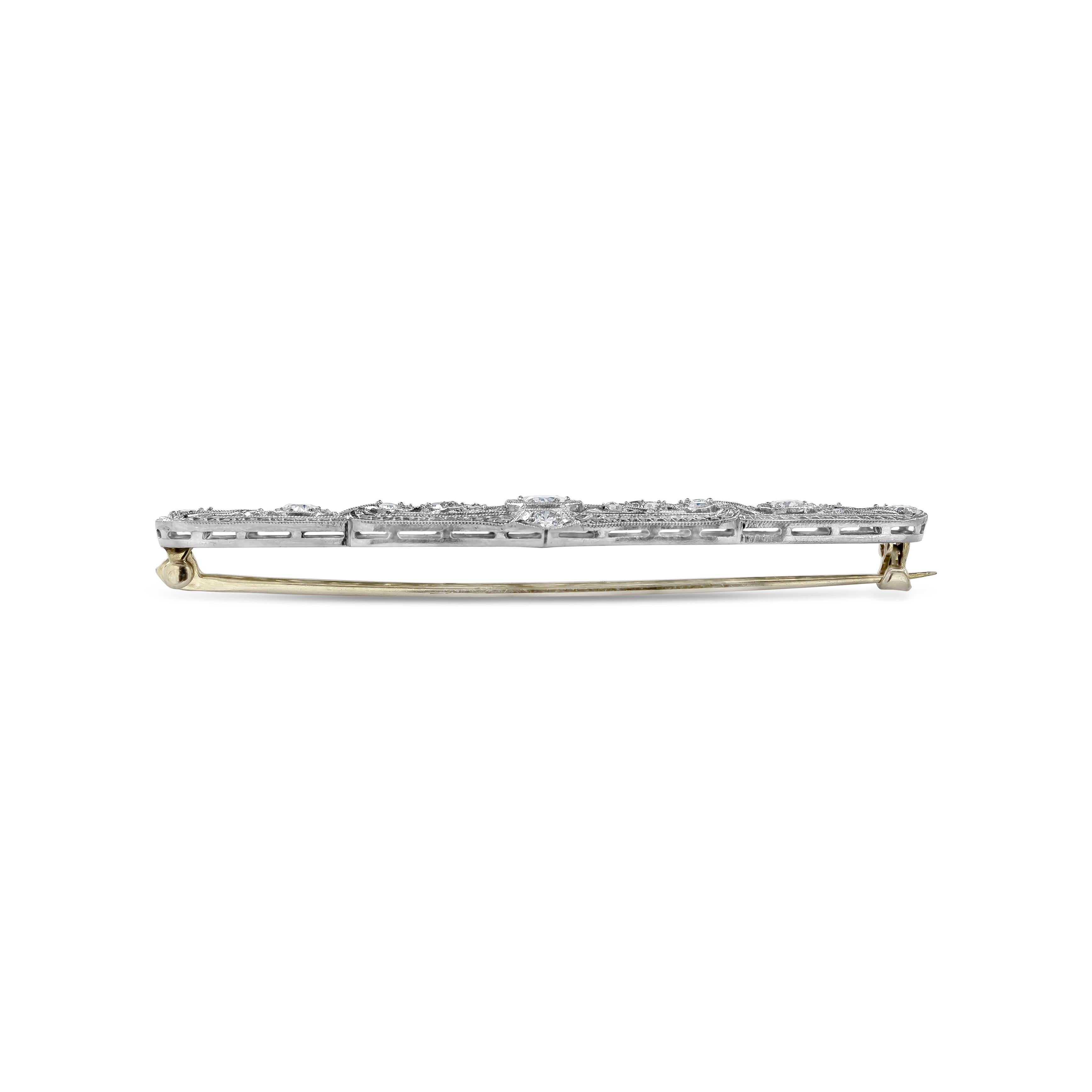 A long panel brooch of open-work design set with old European cut diamonds weighing 0.88 carats total. Hand-engraved with an intricate design. Made in Platinum.

