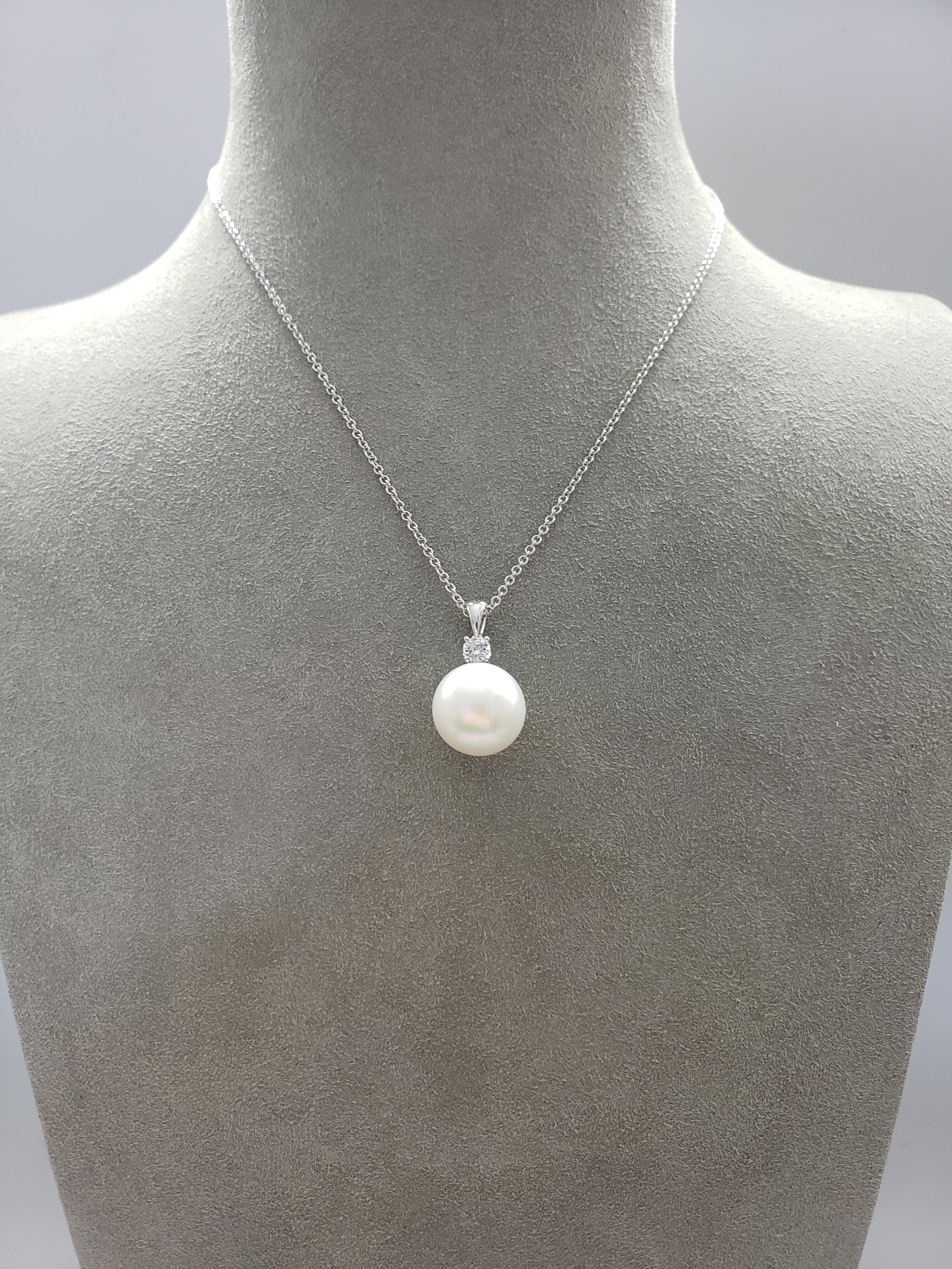 A pearl necklace showcasing a 14 millimeter South Sea pearl accented by a single brilliant round diamond weighing 0.26 carats total. Set in 18 karat white gold. Attached to a 18 inch white gold chain. 
