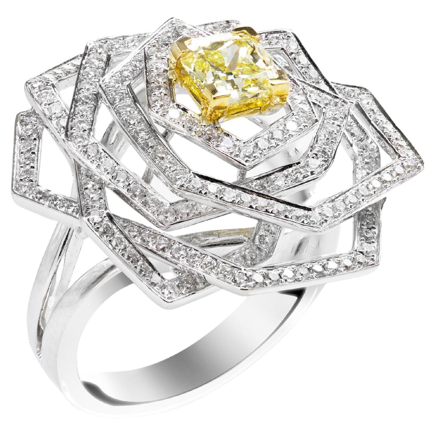 A chic cocktail ring, showcasing a 0.81 carat radiant cut diamond certified by GIA as Fancy Intense Yellow color and VS2 clarity, set on a four prong setting made of 18K yellow gold. Surrounded by a cluster of geometric shapes featuring round