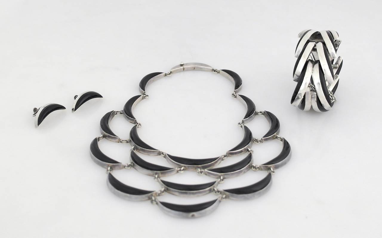 Being offered is a .970 silver jewelry suite by Antonio Pineda of Taxco, Mexico. Suite consists of a necklace, bracelet and earrings, all bearing the onyx crescent moon motif. Marked as illustrated. In excellent condition.
