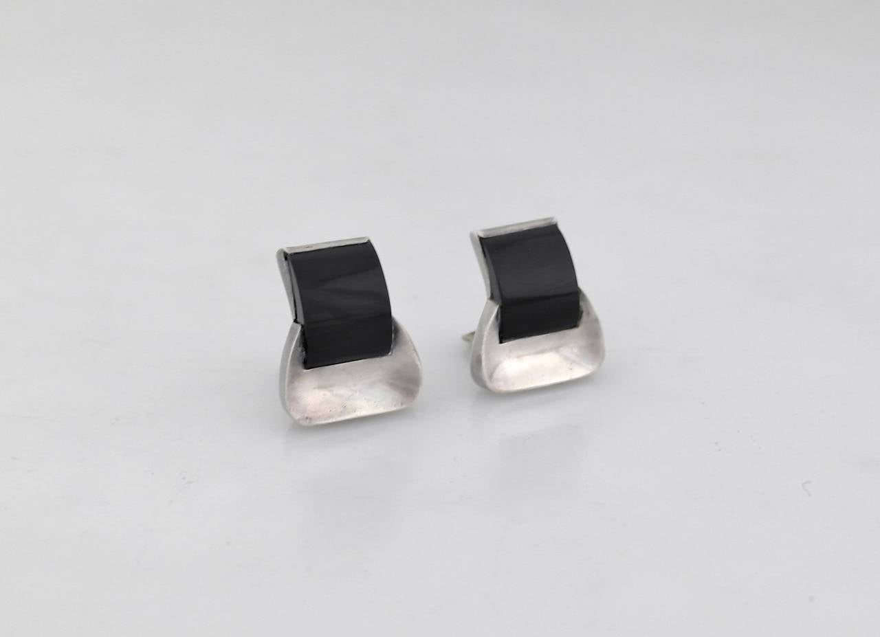 Being offered are a circa 1967 pair of earrings by Antonio Pineda of Taxco, Mexico. Modernist form with applied onyx stones on silver mounts. Dimensions:      Marked as illustrated. In excellent condition.

Stanley Szaro Antonio Pineda