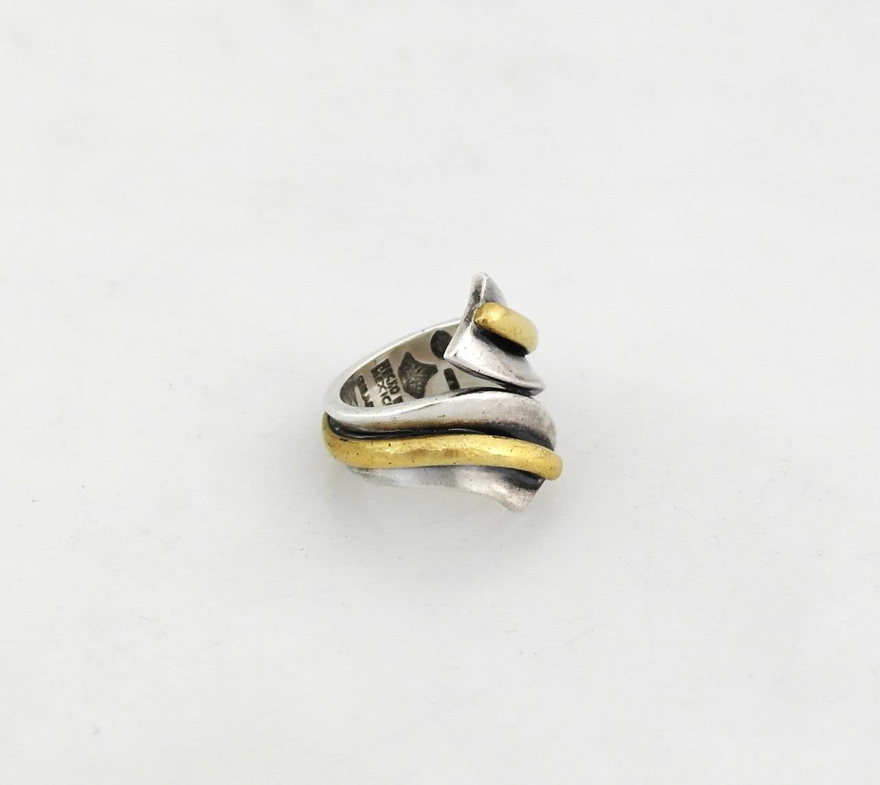 Being offered is a circa 1961 .970 silver ring by Antonio Pineda of Taxco, Mexico. Twist form ring with applied brass at the center. Dimensions:      Marked as illustrated. In excellent condition.

Stanley Szaro Antonio Pineda Collection

In the
