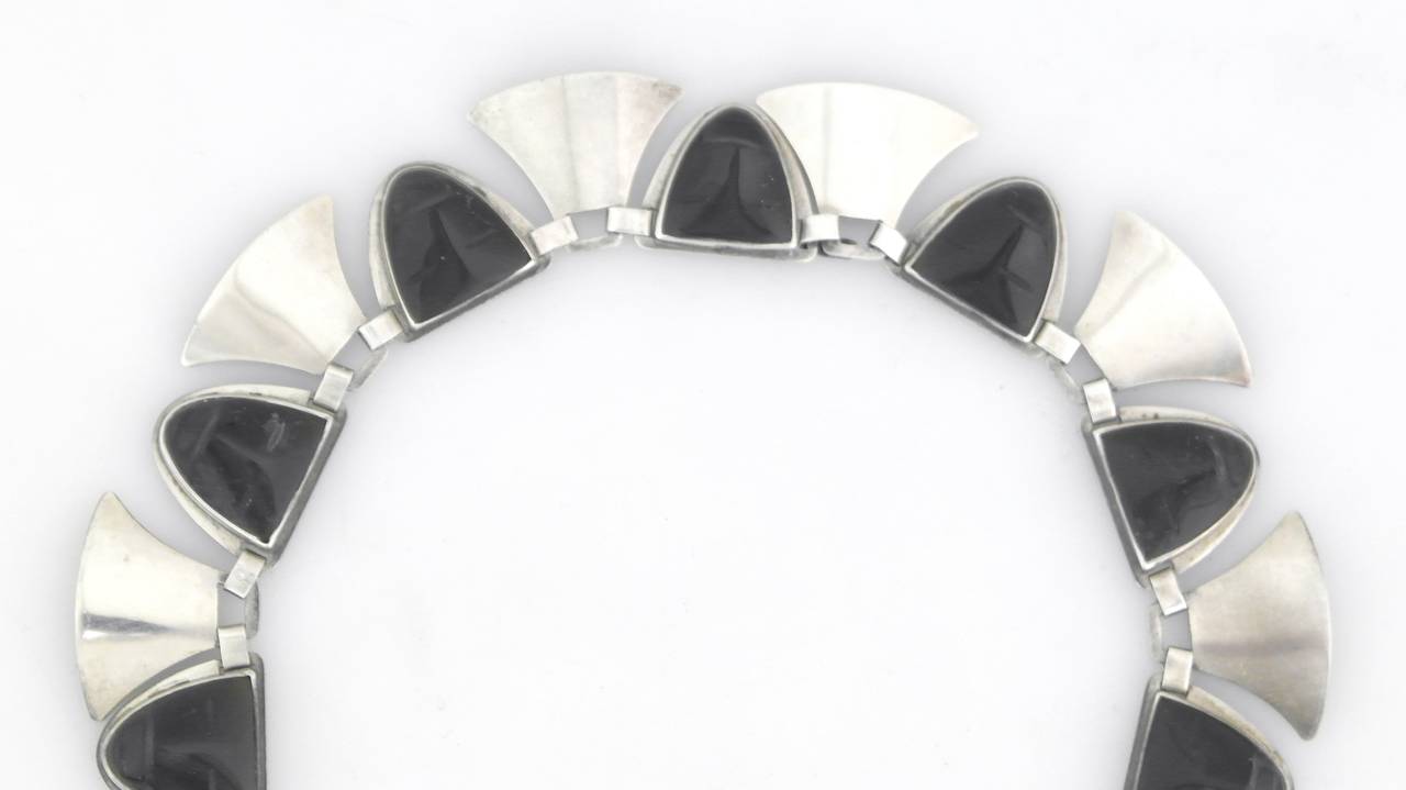 Being offered is a circa 1940s sterling silver necklace & bracelet by Fred Davis of Taxco, Mexico. Handmade set with carved onyx native faces between silver links. Dimensions: Necklace - 15