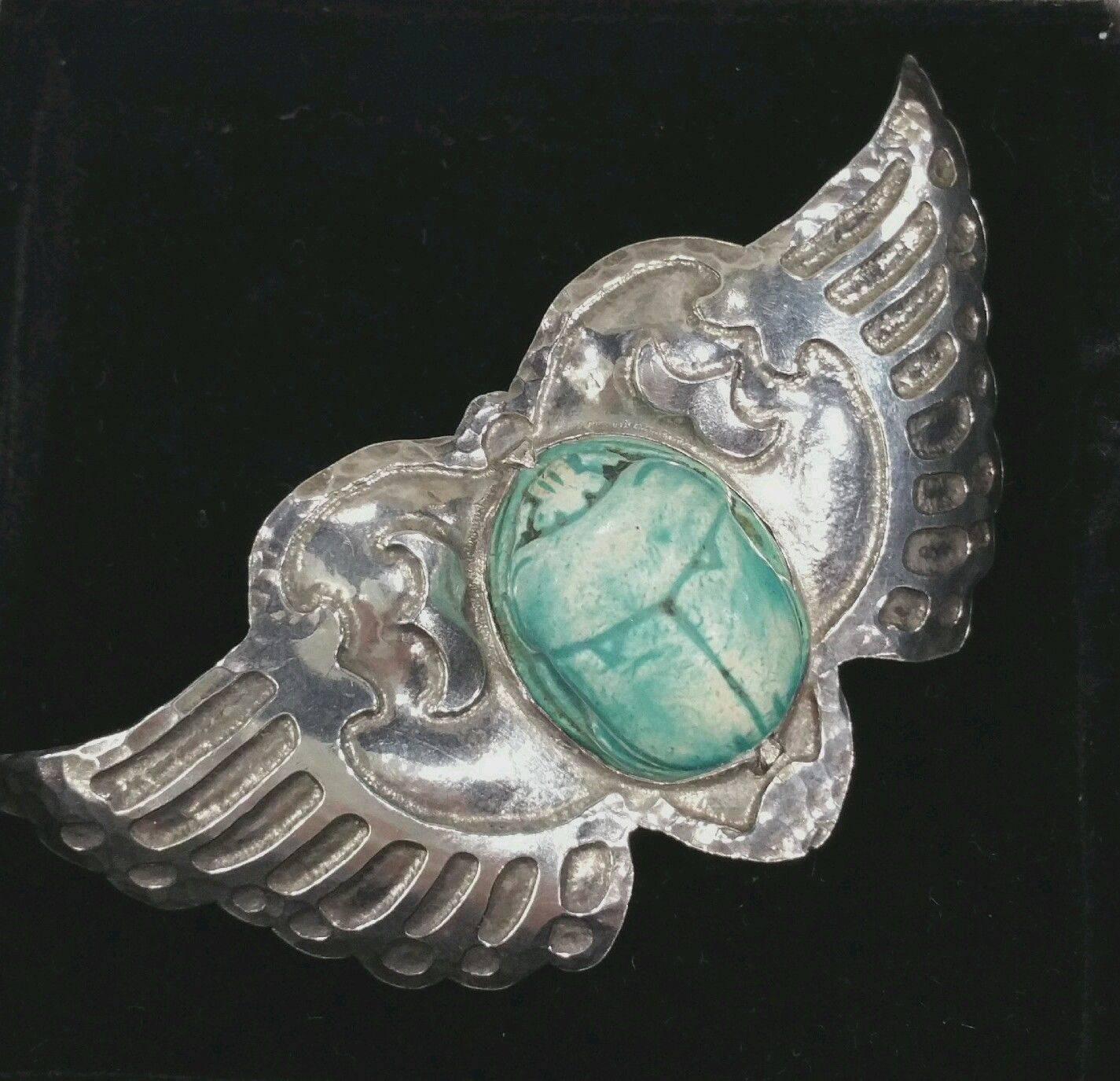 Being offered is an exceedingly rare sterling silver pin by Marshall Field of Chicago, Illinois. Incredible pin comprising a handwrought winged design; at the center, an intricately carved scarab. Dimensions : 3 1/4 inches x 1 3/4 inches. Marked as