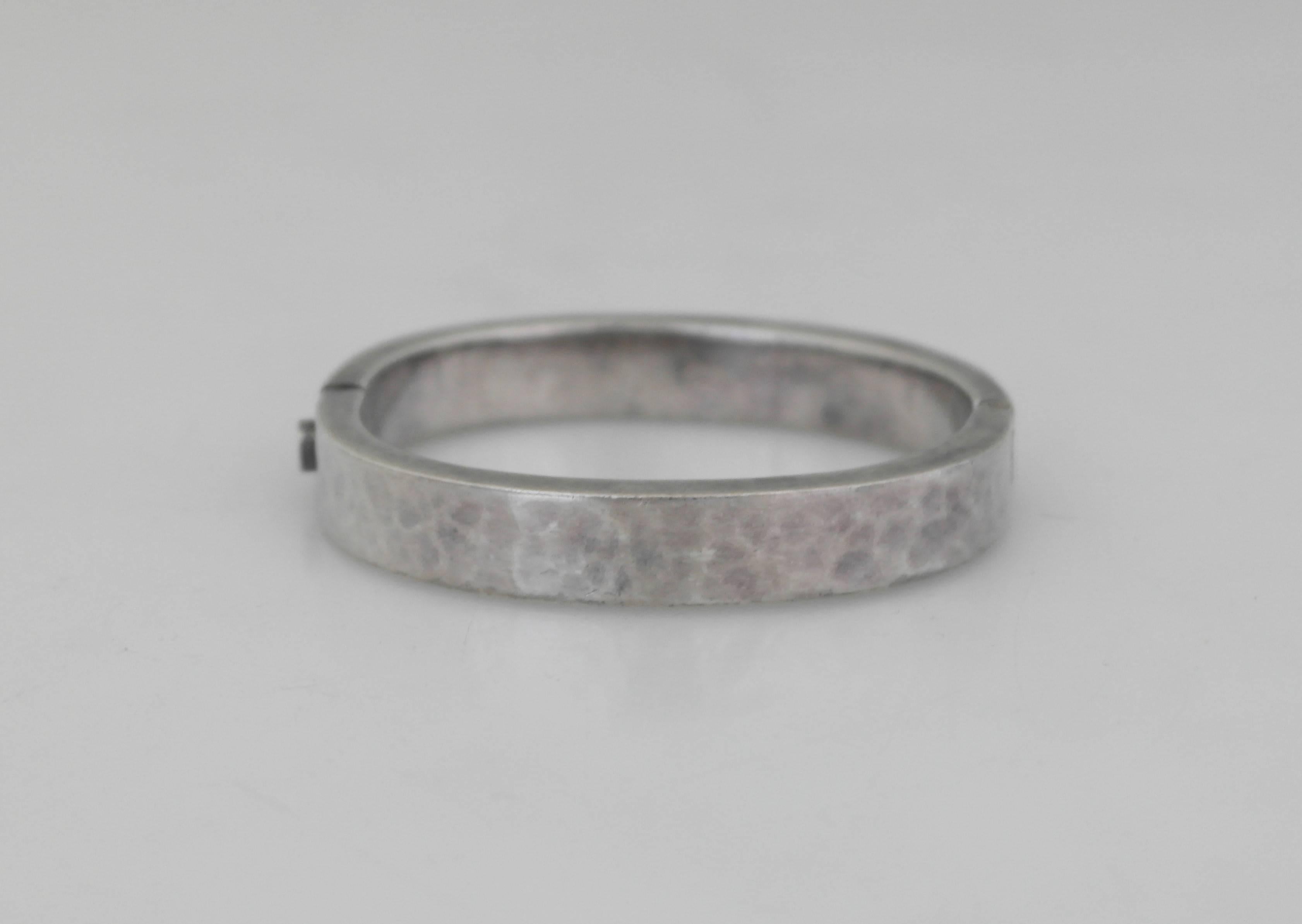 Being offered is a sterling silver bracelet by Paz of Taxco, Mexico. Bangle hinged bracelet has a lightly hammered surface. Dimensions: 1/2 inch wide x 6 3/4 inches (wearable). Marked as illustrated. In excellent condition.