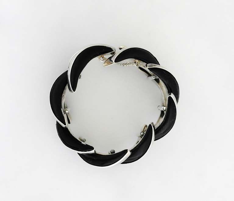 Being offered is a circa 1970s sterling silver bracelet by Los Ballesteros of Taxco, Mexico, in an art deco motif, with swirls of silver and elliptical spheres of onyx.  Bracelet is 1 3/4 inches wide (inner dimensions 7 1/4