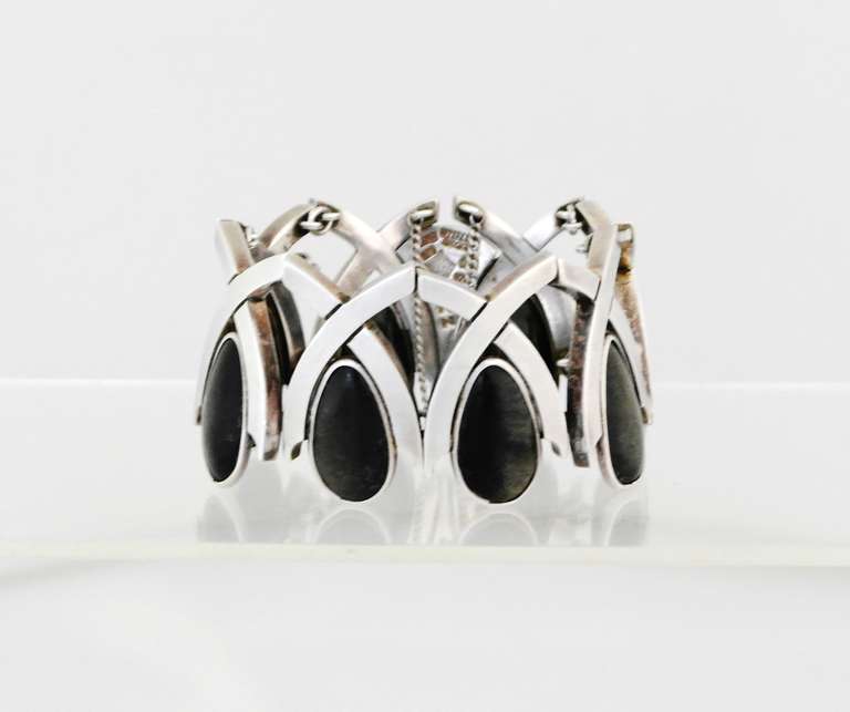 Being offered is a circa 1960s .970 silver bracelet by Antonio Pineda of Taxco, Mexico of modernist design, each 'x' holding a tear shaped piece of onyx.  Dimensions: 1 3/4