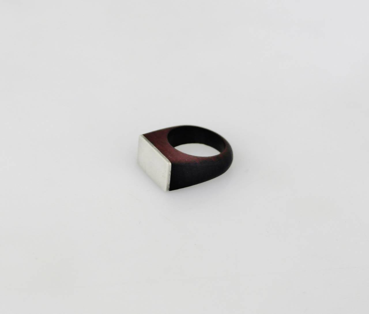 Being offered is a circa 1953 ring by William Spratling of Taxco, Mexico; made during his third design period (1951-1967). Sterling silver layer applied to a carved rosewood ring. Size 8. Marked as illustrated. In excellent condition.

Stanley