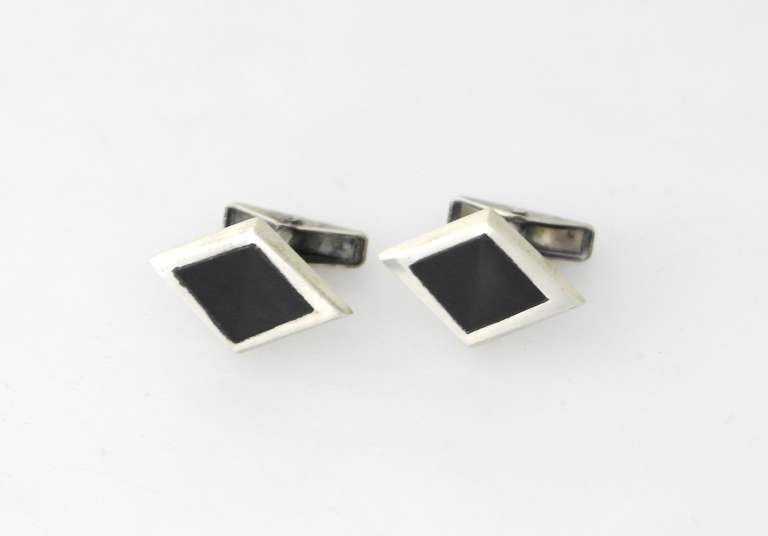 Being offered are a pair of sterling silver cufflinks by Alan Adler of California; Diamond shaped pair adorned with onyx inlay. Dimensions: 1