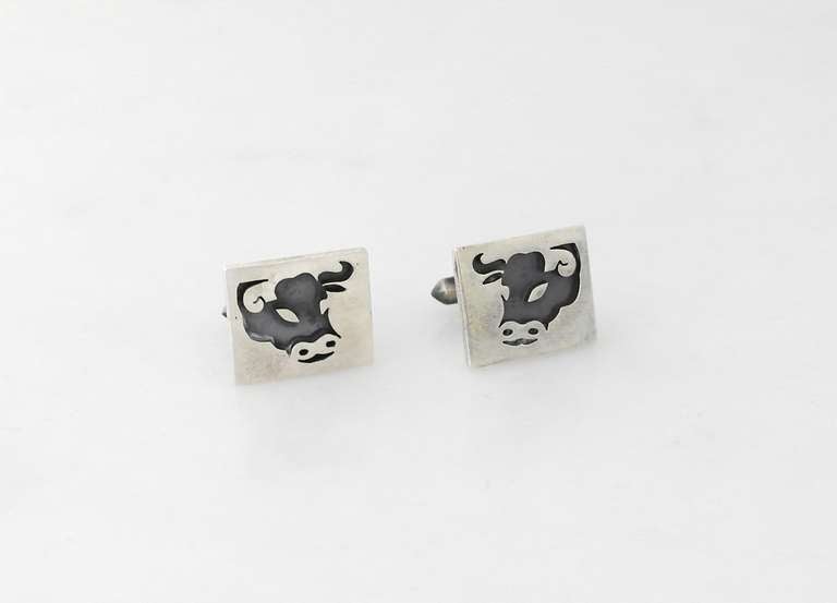 Being offered are a pair of circa 1967 .970 silver cufflinks by Antonio Pineda of Taxco, Mexico; pierced bull design with oxidized surface resembling a shadow box effect. Dimensions: 7/8