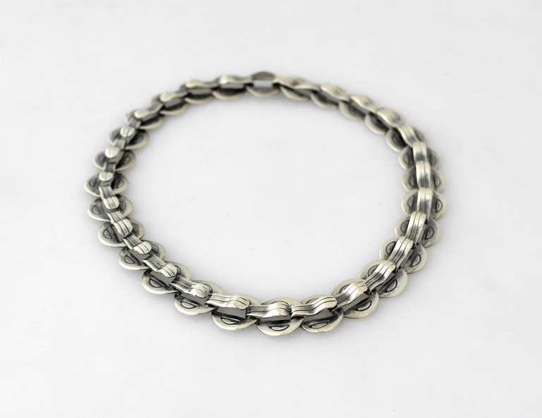 Being offered is a circa 1958 .940 silver necklace by Hector Aguilar of Taxco, Mexico. Handmade piece comprising circular curved links decorated with incised lines. Dimensions: 15 1/2