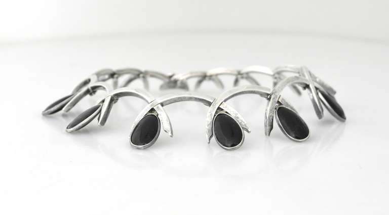 Being offered is a fine circa 1960s .970 silver necklace by Antonio Pineda, of Taxco, Mexico; sought after design with crossing arches supporting tear drop shaped onyx stones; tongue closure. Dimensions: 19